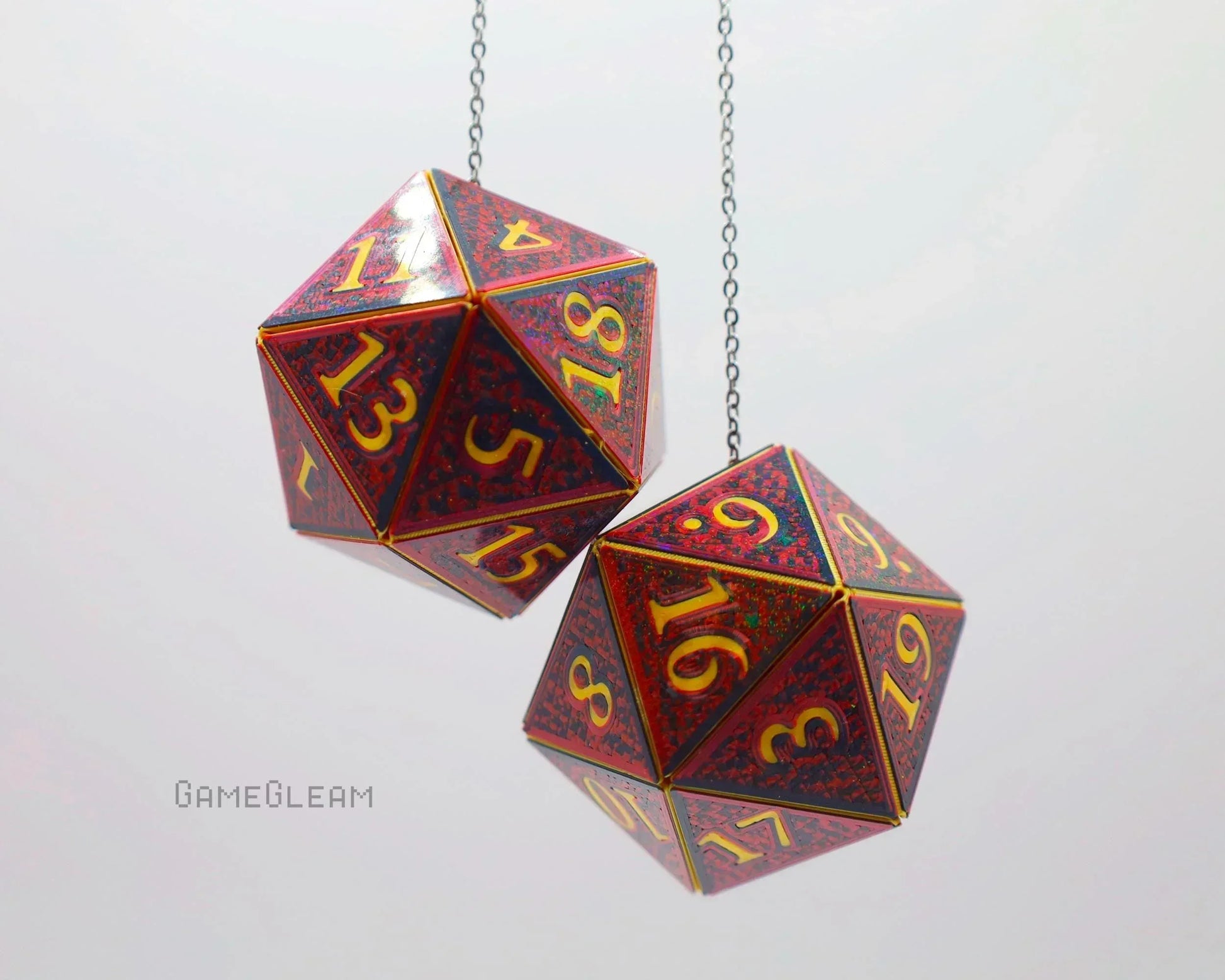 Pair of holographic red twenty-sided dice car charms with gold numbers, hanging from chains.
