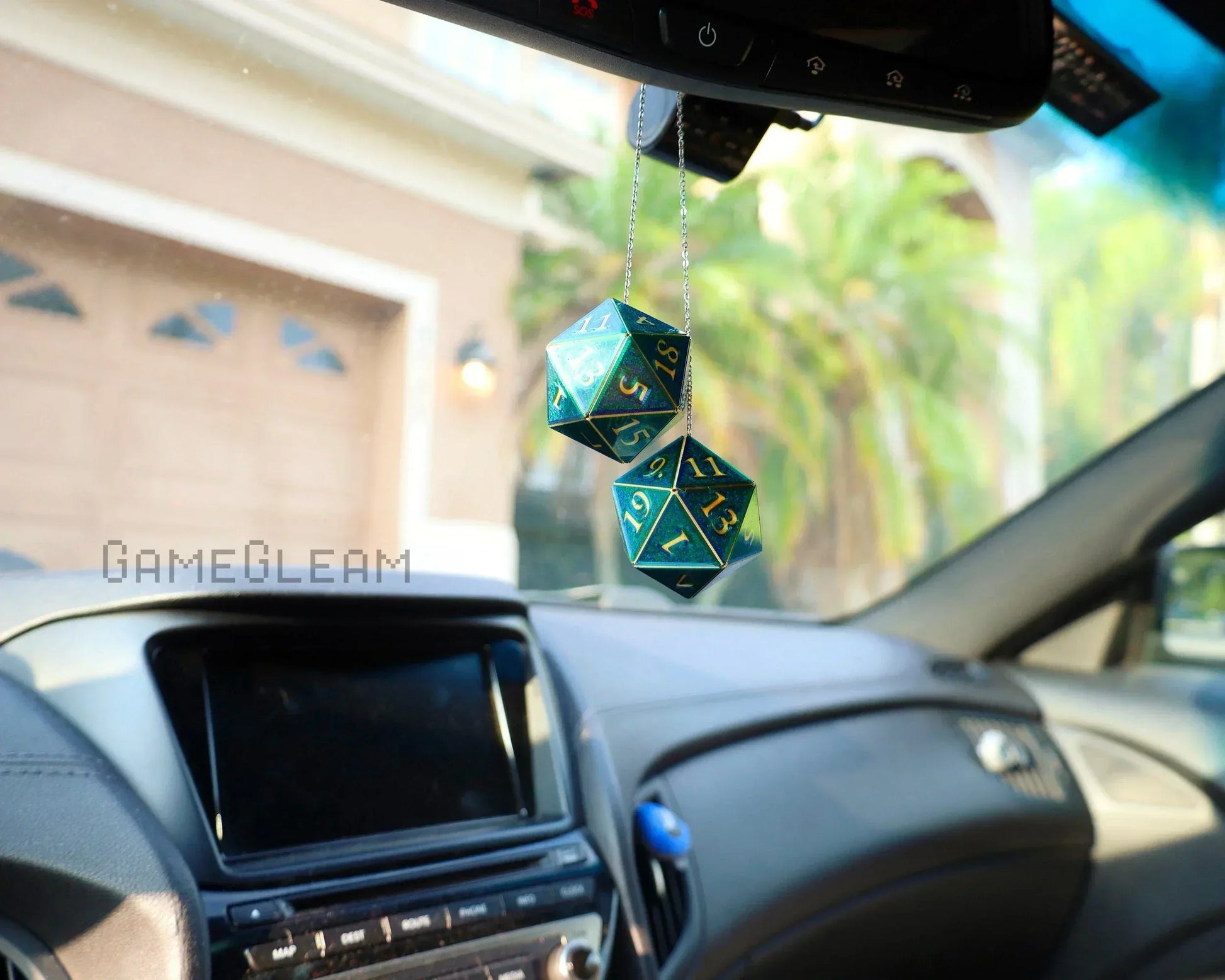 Holographic green twenty-sided dice car mirror charm with gold numbers in a vehicle interior