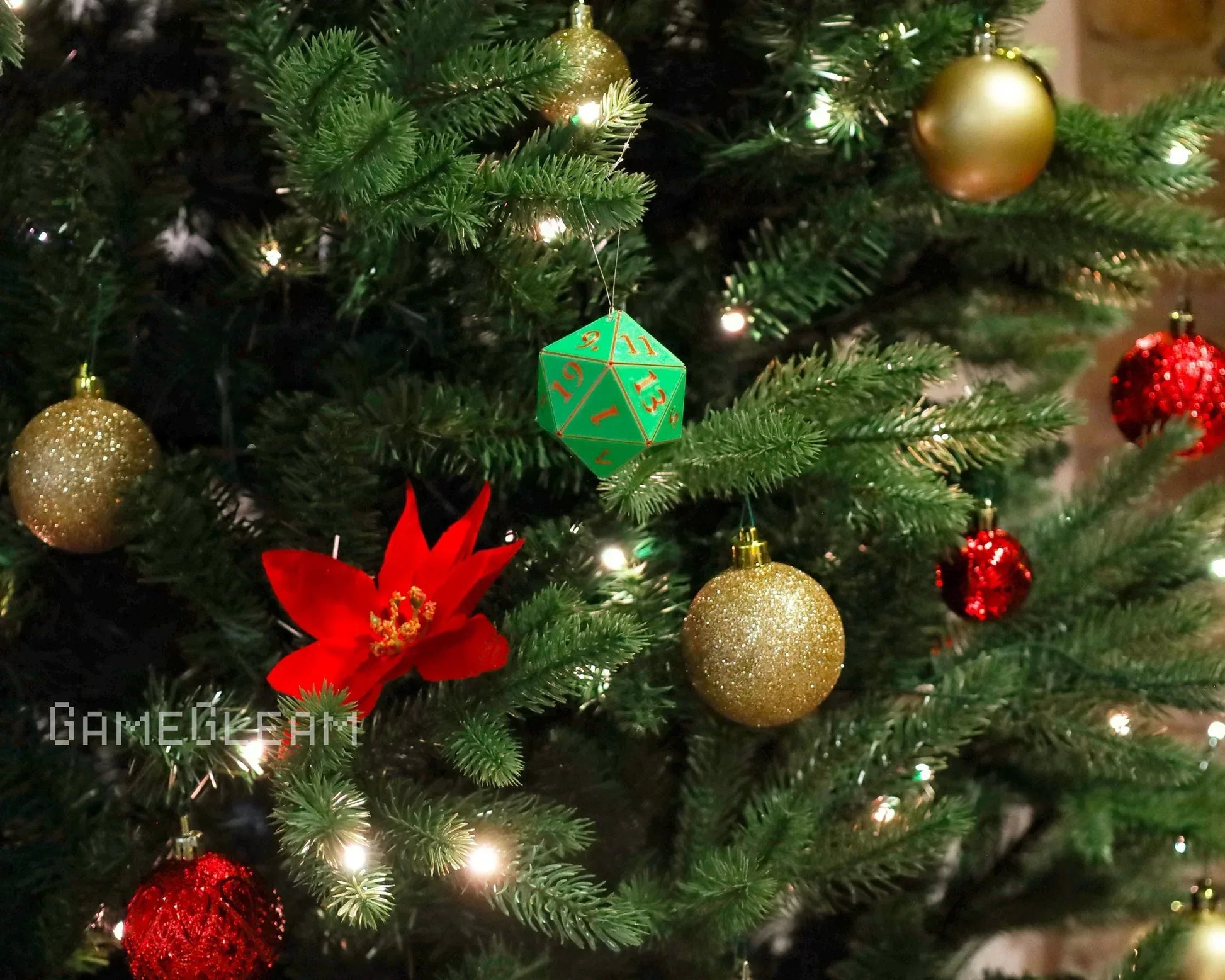 Green polyhedral dice ornament hanging on a Christmas tree with red and gold baubles