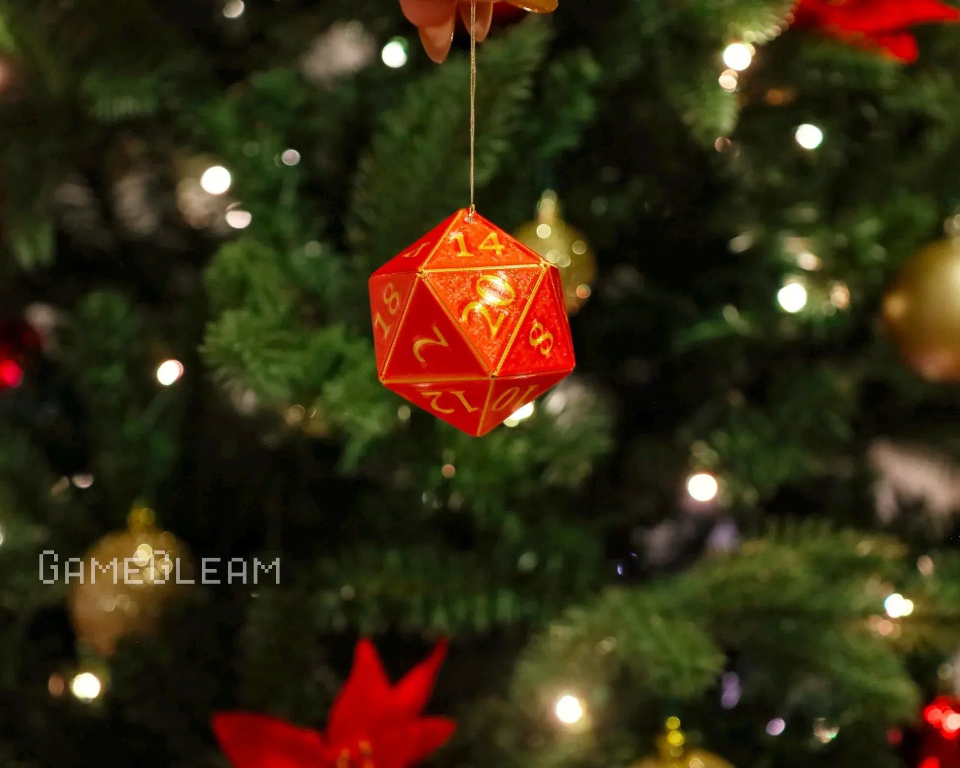 Red twenty-sided dice ornament with yellow numbers hanging on a Christmas tree