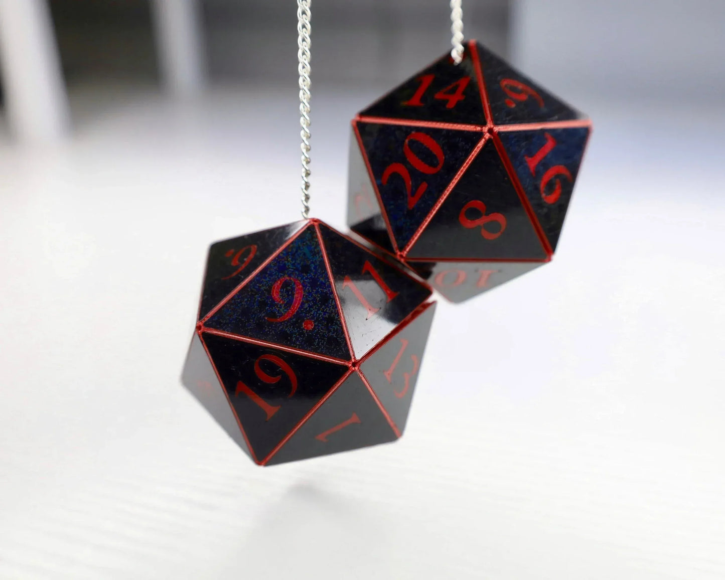 Holographic black twenty-sided dice car charm with red numbers on a chain, tabletop RPG accessory