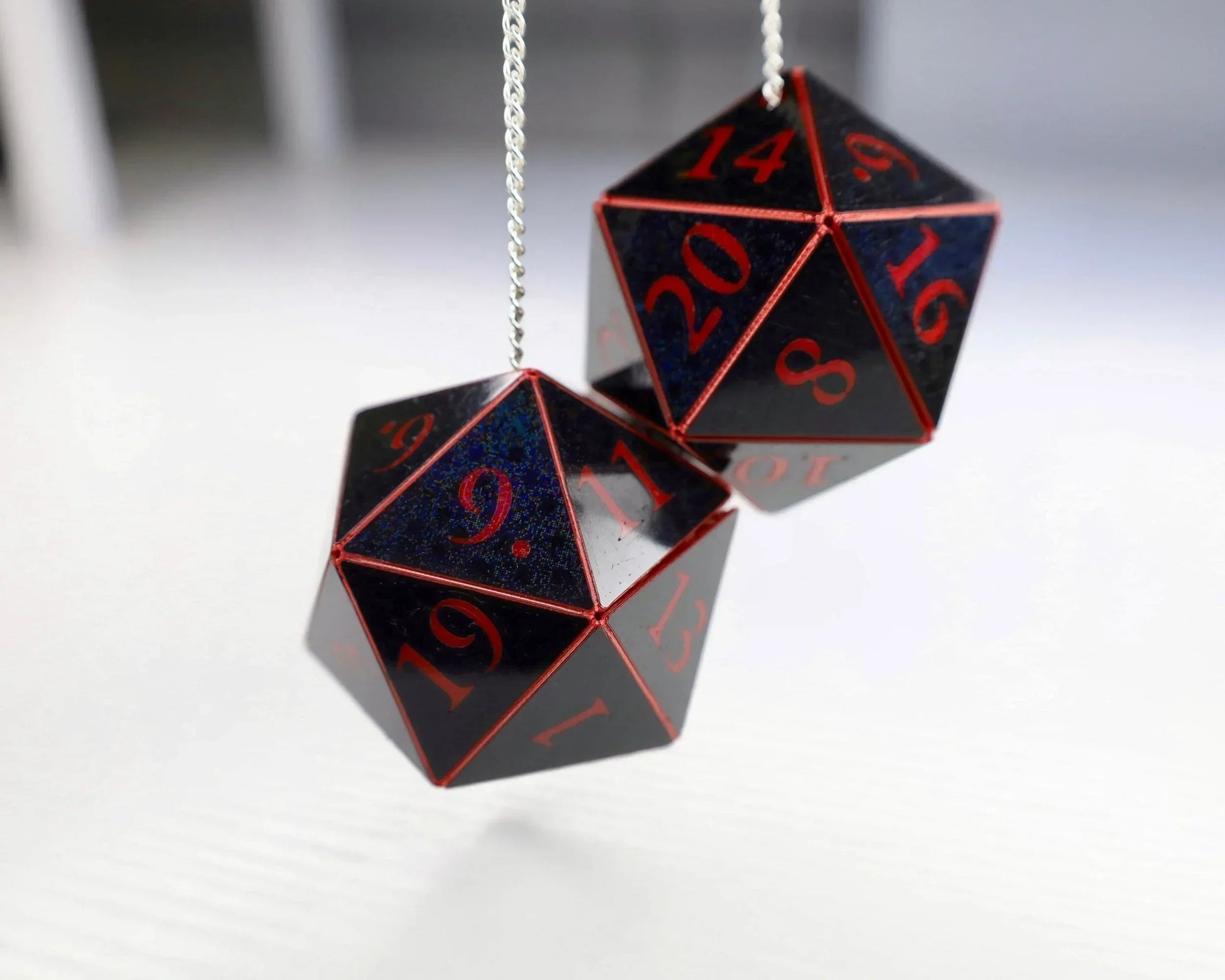 Holographic black twenty-sided dice car charm with red numbers on a chain, tabletop RPG accessory