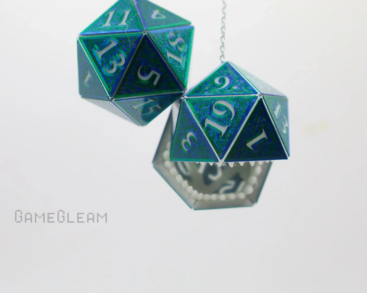 Holographic green 20-sided dice car charm with teeth detail, hanging on a chain