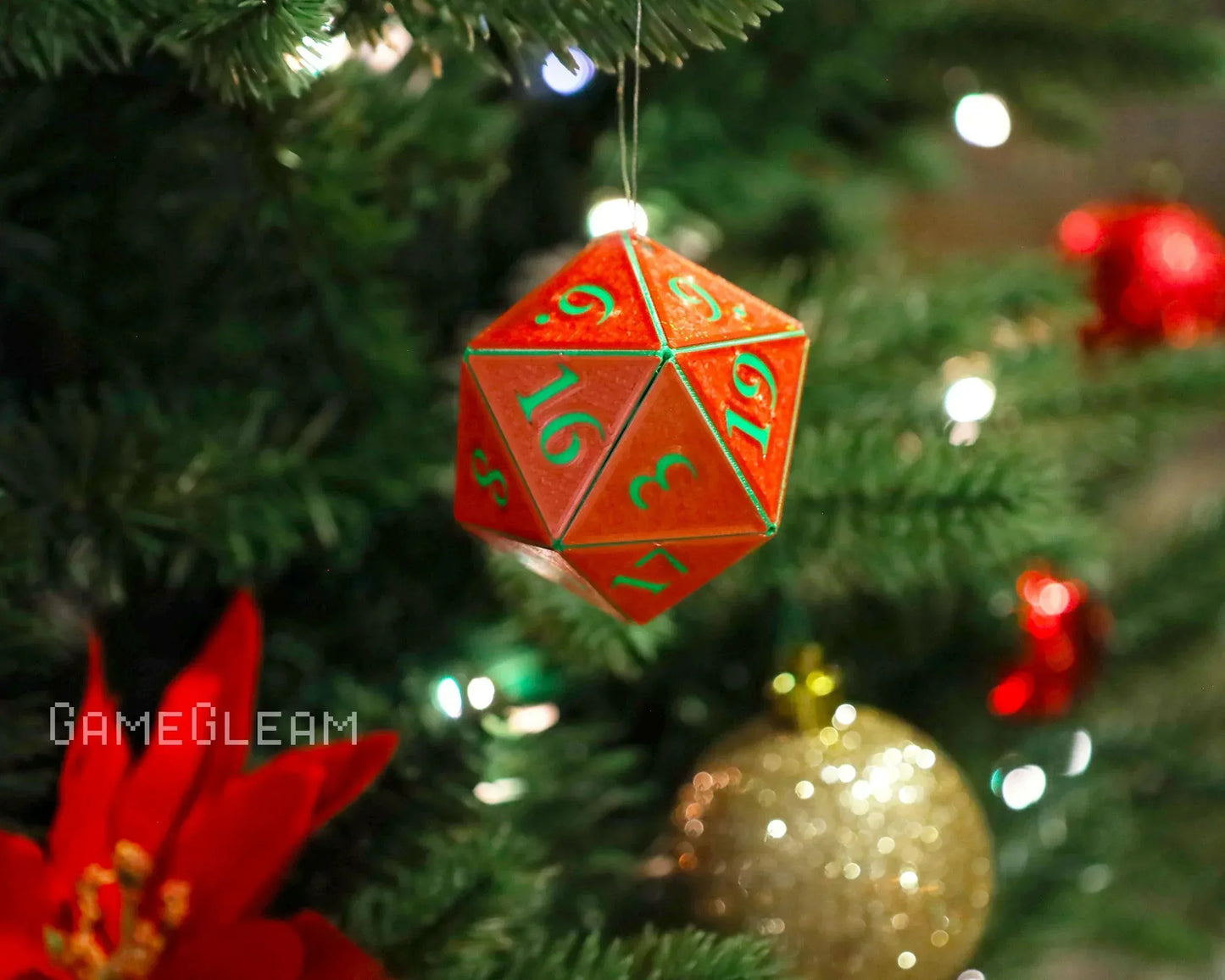 Red twenty-sided dice ornament with green numbers hanging on a decorated Christmas tree