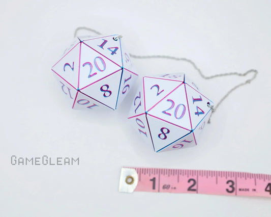 Pair of holographic twenty-sided dice car charms with chain, next to measuring tape