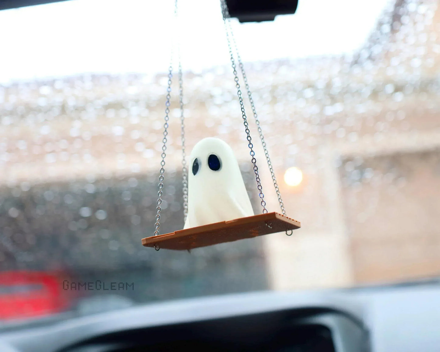 Cute ghost car charm figurine sitting on a swing, hanging from rearview mirror