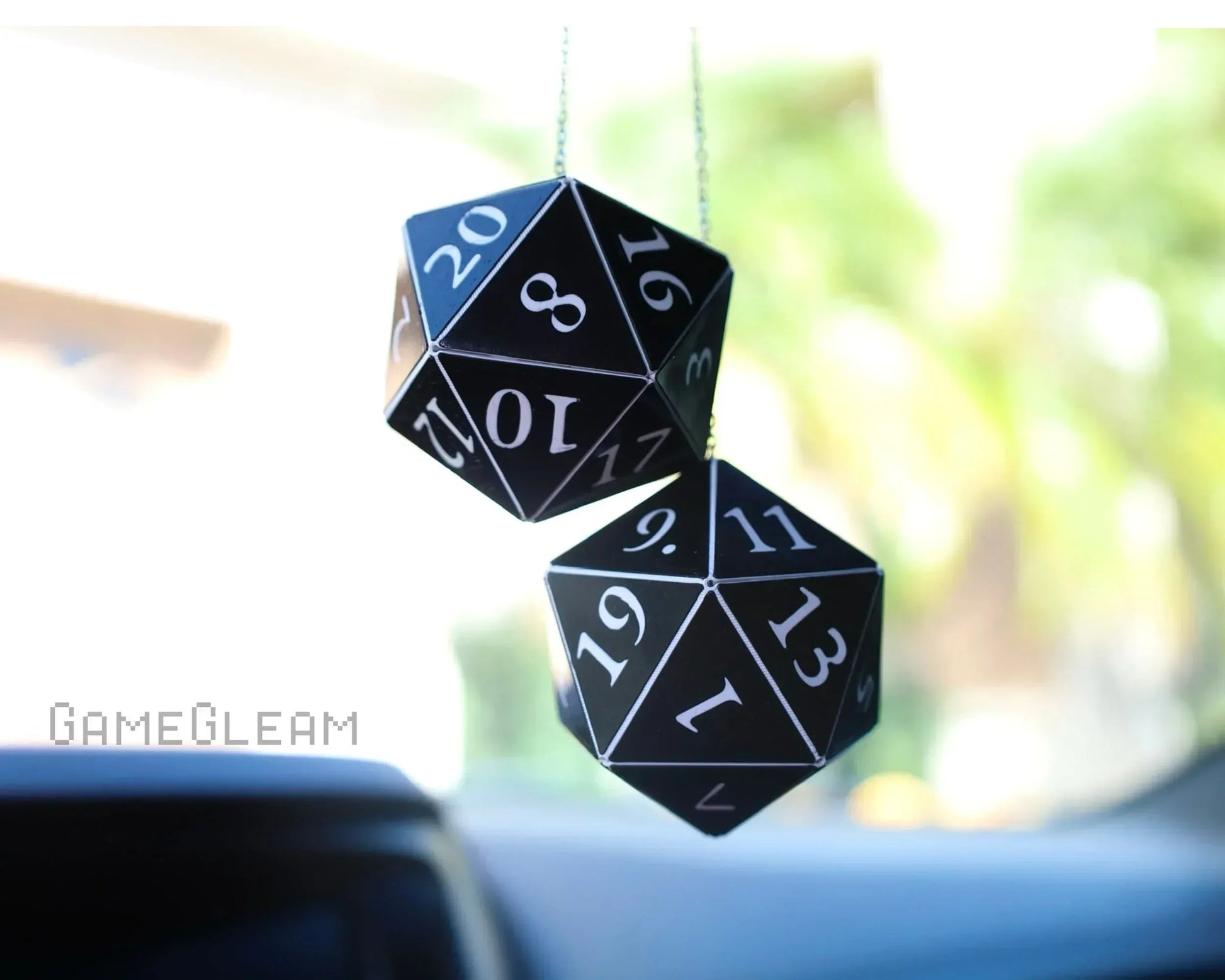 Black twenty-sided dice car charm hanging from rearview mirror with white numbers