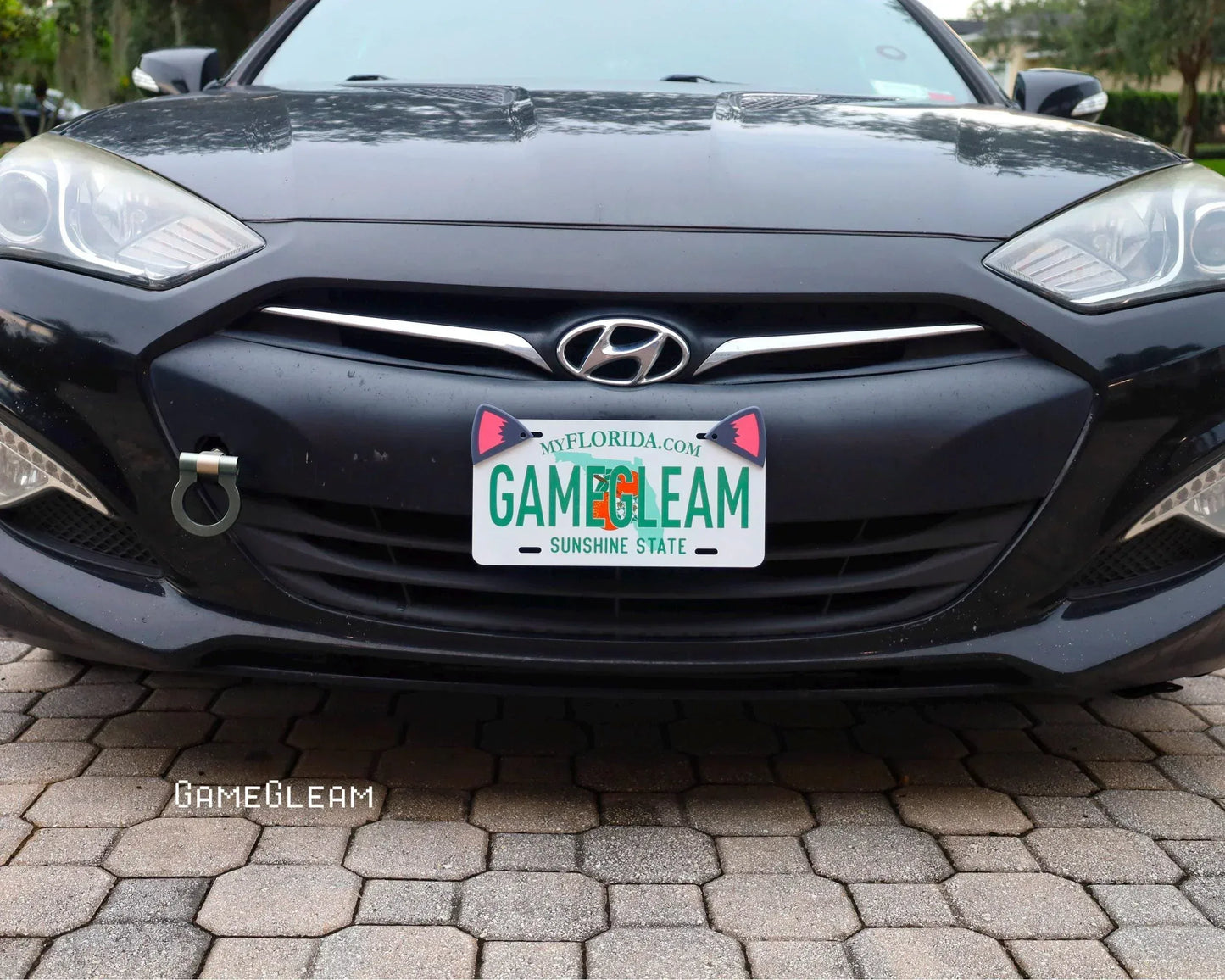 Front of a black Hyundai car with a custom Florida license plate that reads GAMEGLEAM.