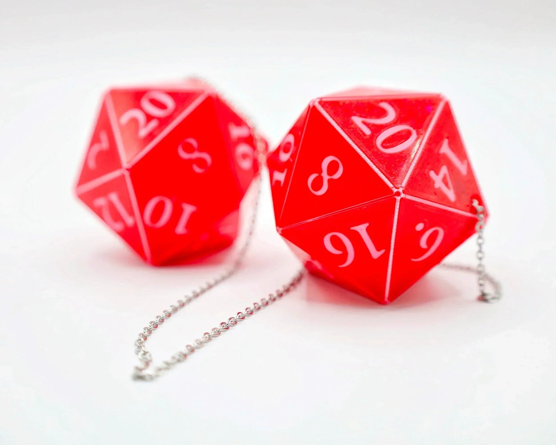 Red twenty-sided dice car charms with silver chain, tabletop RPG accessories on white background