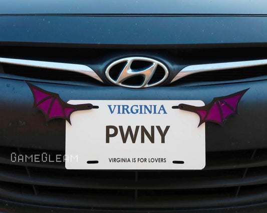 Novelty car license plate frame with purple bat wings mounted on a Hyundai vehicle.