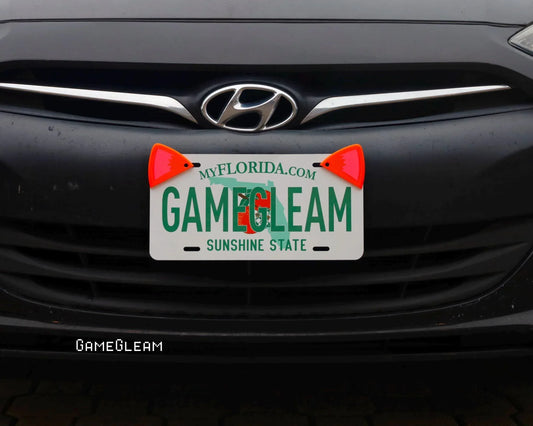 Florida license plate on a car with two orange cat ear accessories attached.