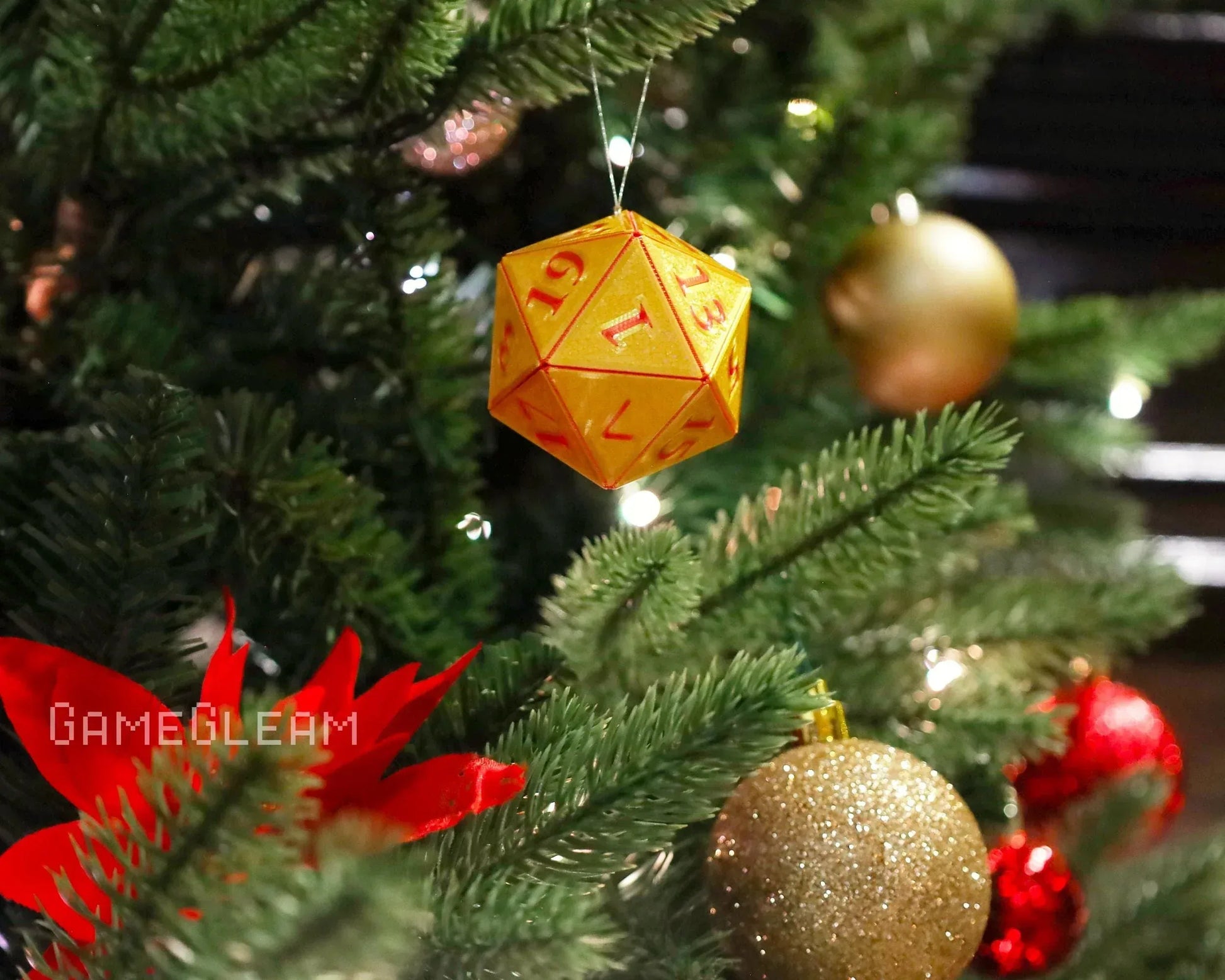 Orange polyhedral dice ornament hanging on a Christmas tree with festive decorations