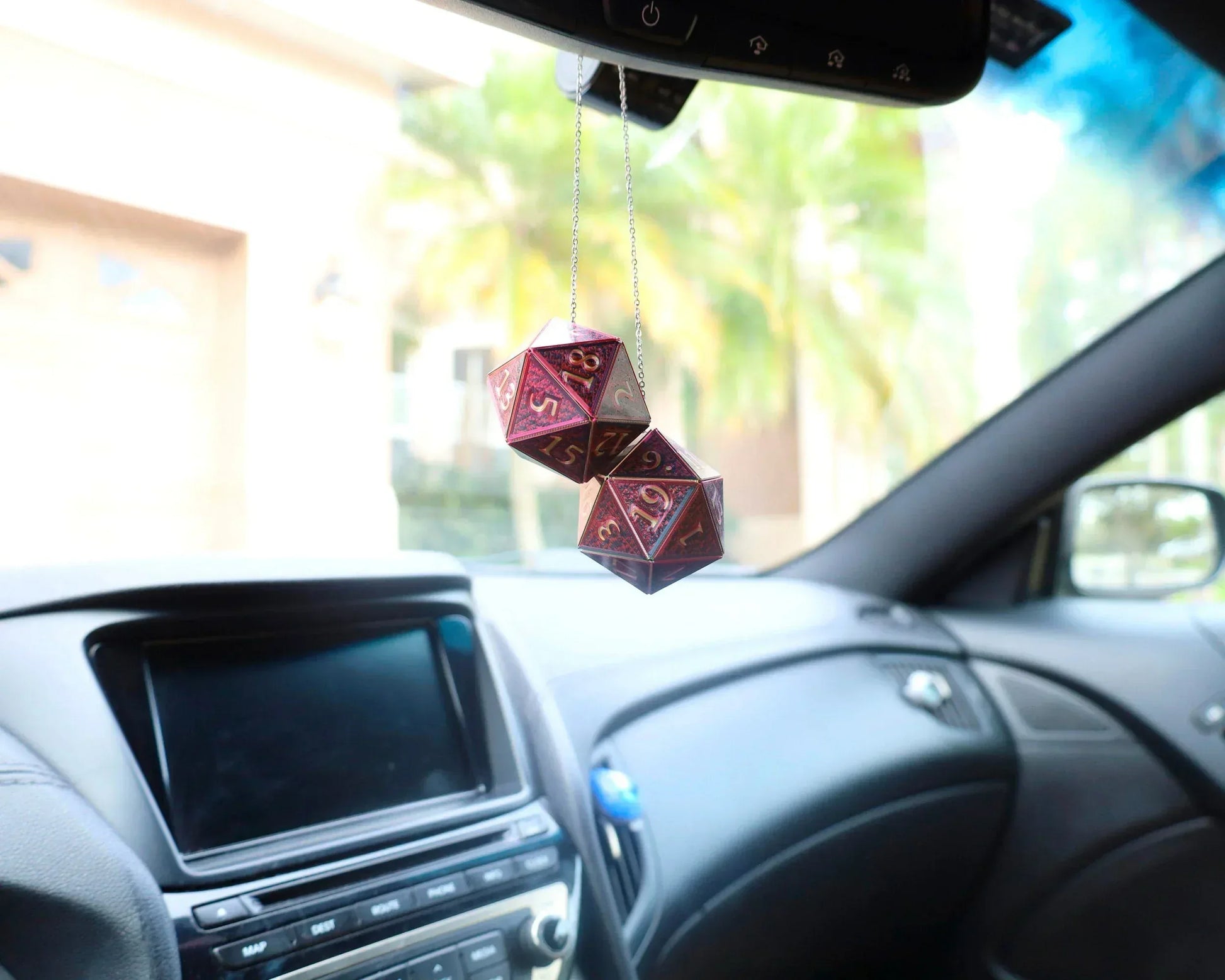 Holographic dice car charm with purple and gold numbers hanging from rearview mirror