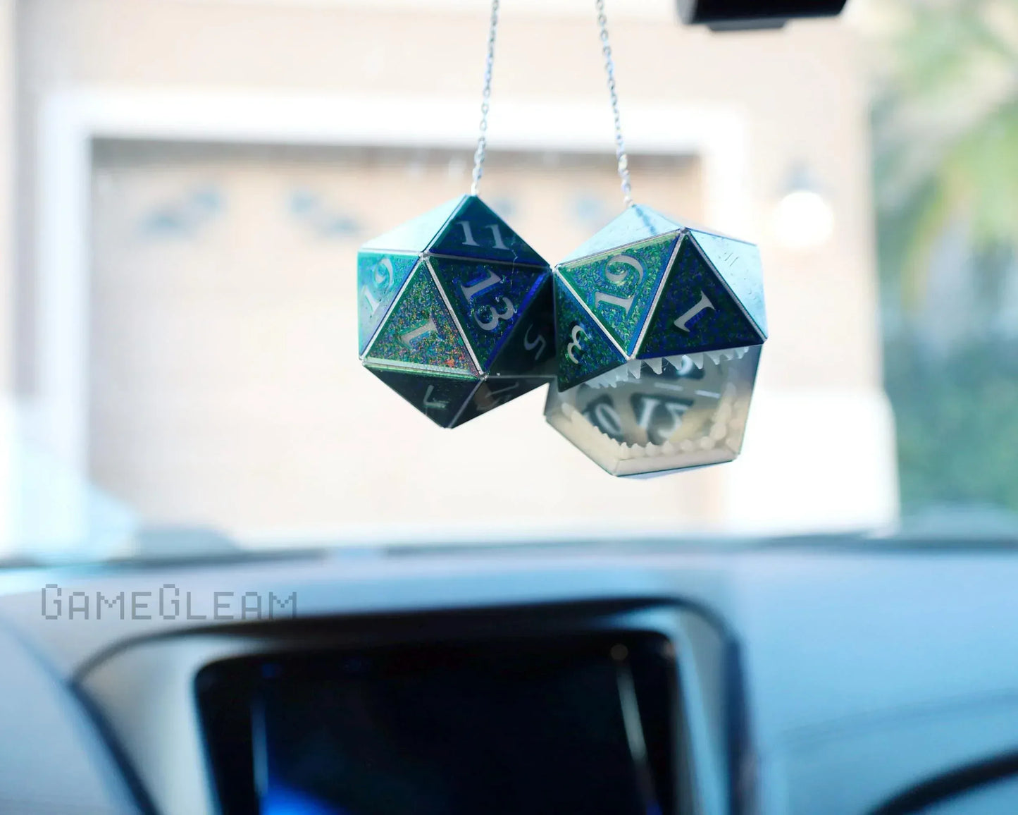 Holographic twenty-sided dice car charm with monster teeth, hanging from a rearview mirror.