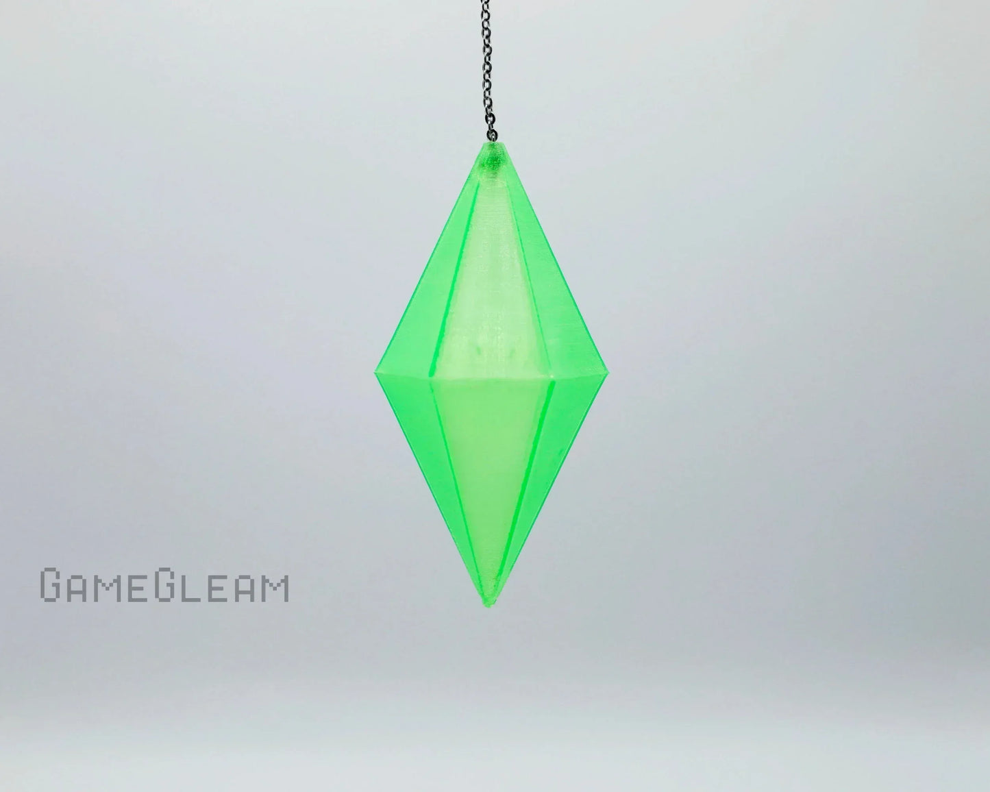 Handmade green crystal pendant dice charm on a chain, gamer car accessory on light background