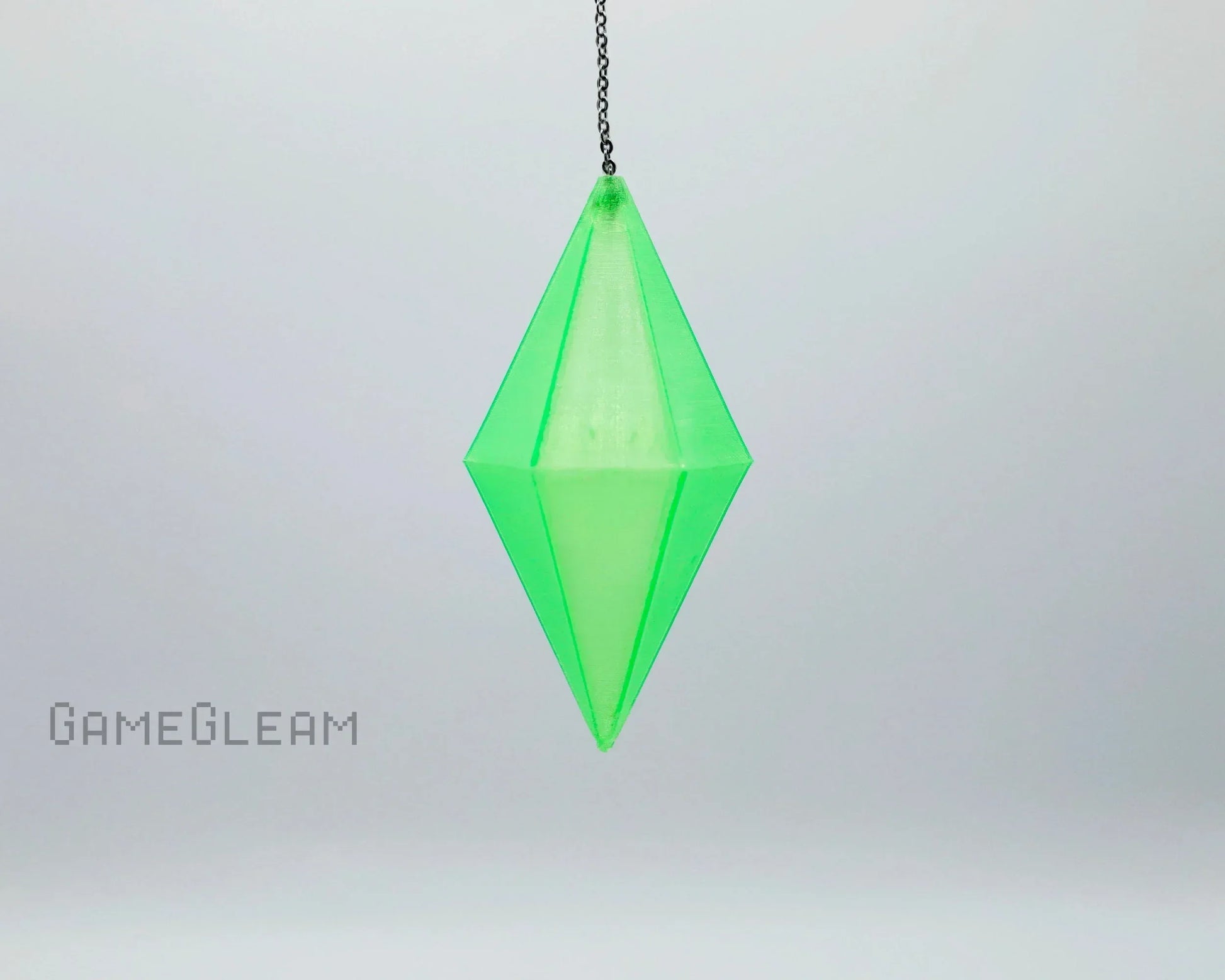 Handmade green crystal pendant dice charm on a chain, gamer car accessory on light background