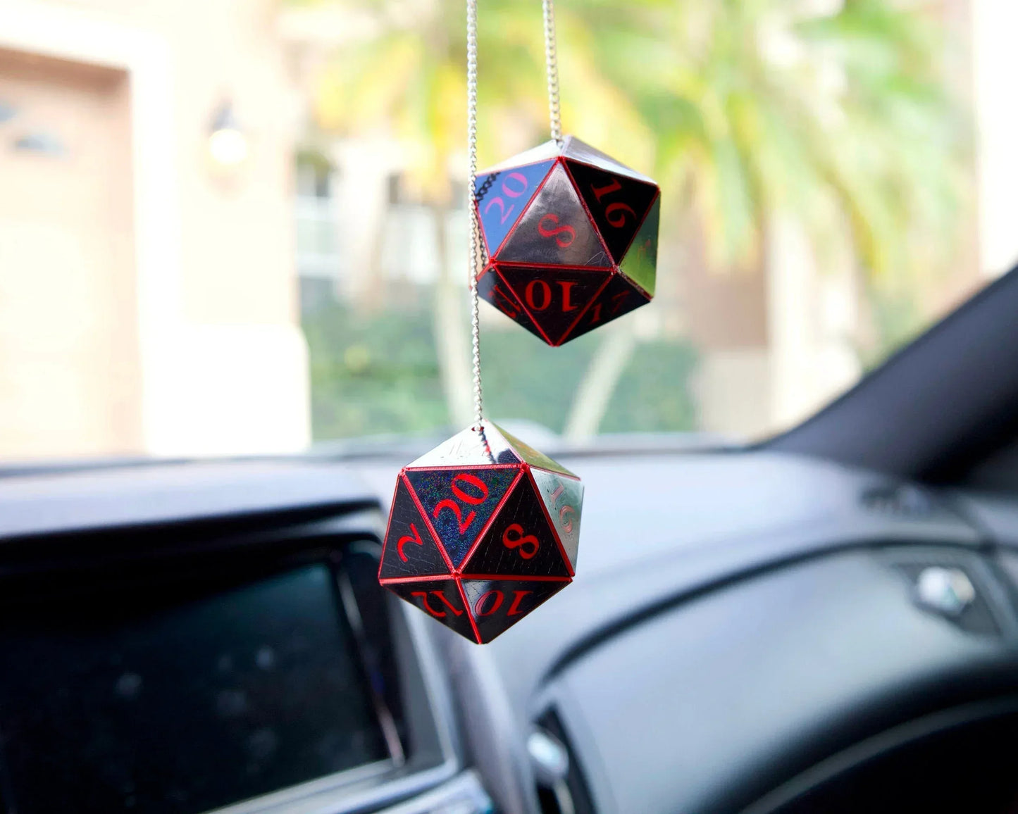 Handmade black and red twenty-sided dice car charms hanging from a rearview mirror