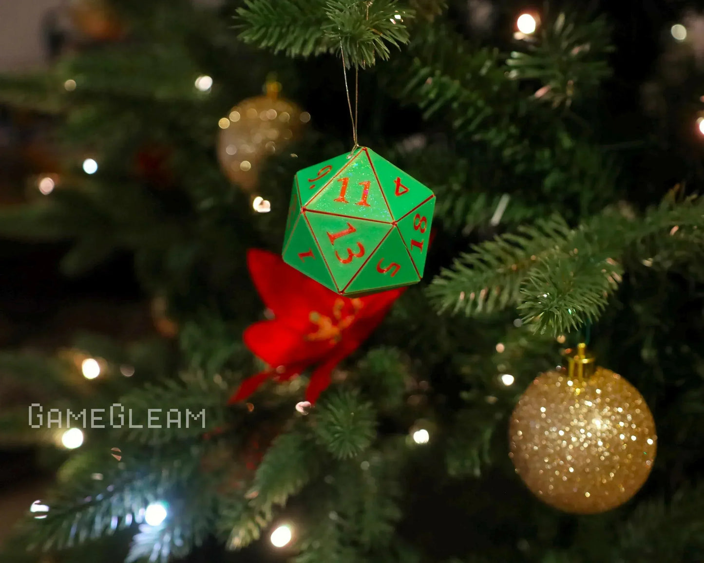 Green 20-sided dice ornament hanging on a Christmas tree with festive decorations.