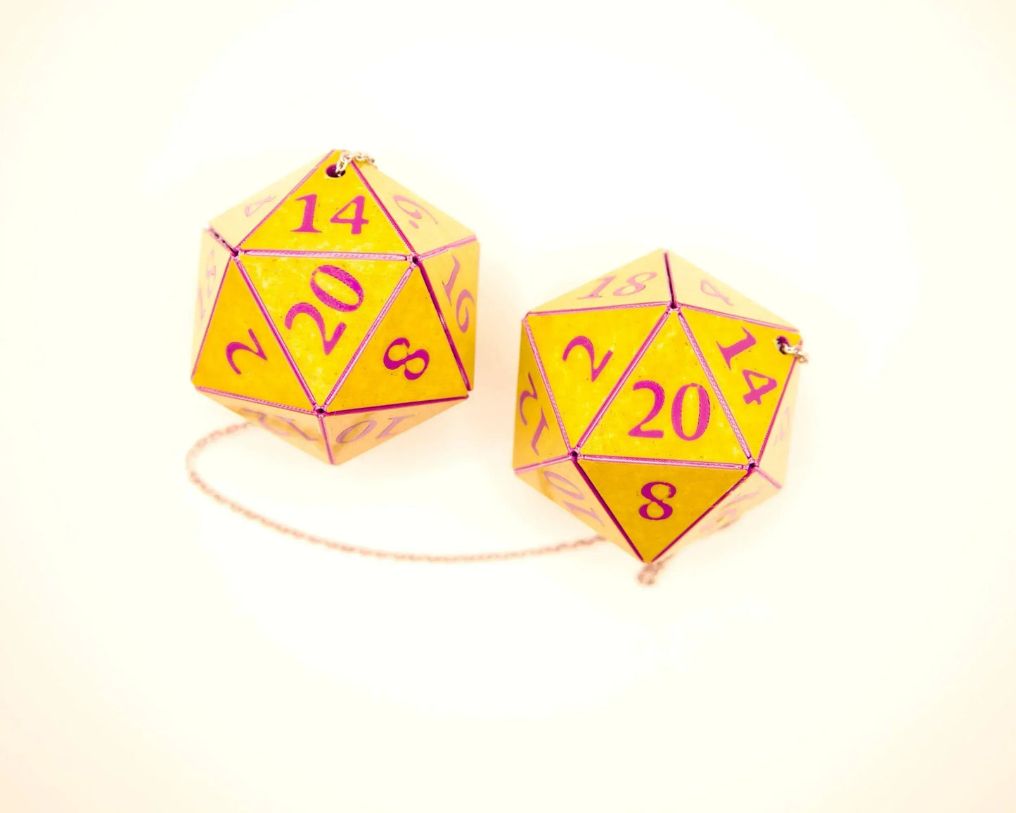 Yellow twenty-sided dice with purple numbers, connected by a chain, for car mirror decor.