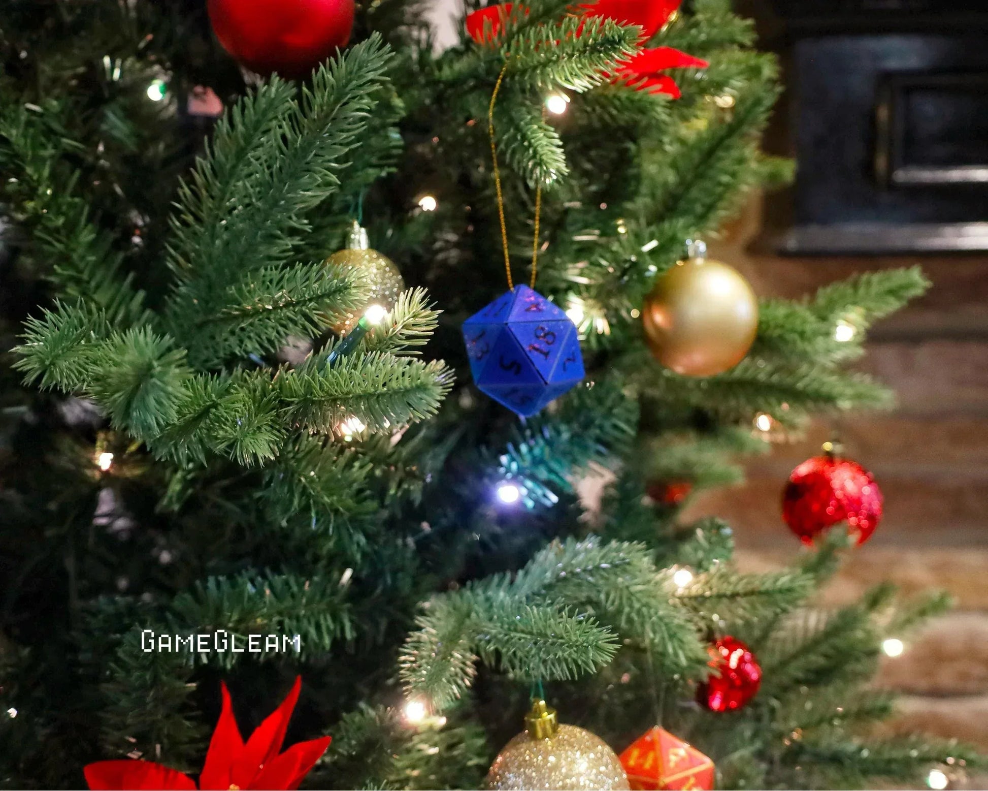 Blue twenty-sided die ornament hanging on decorated Christmas tree with festive baubles