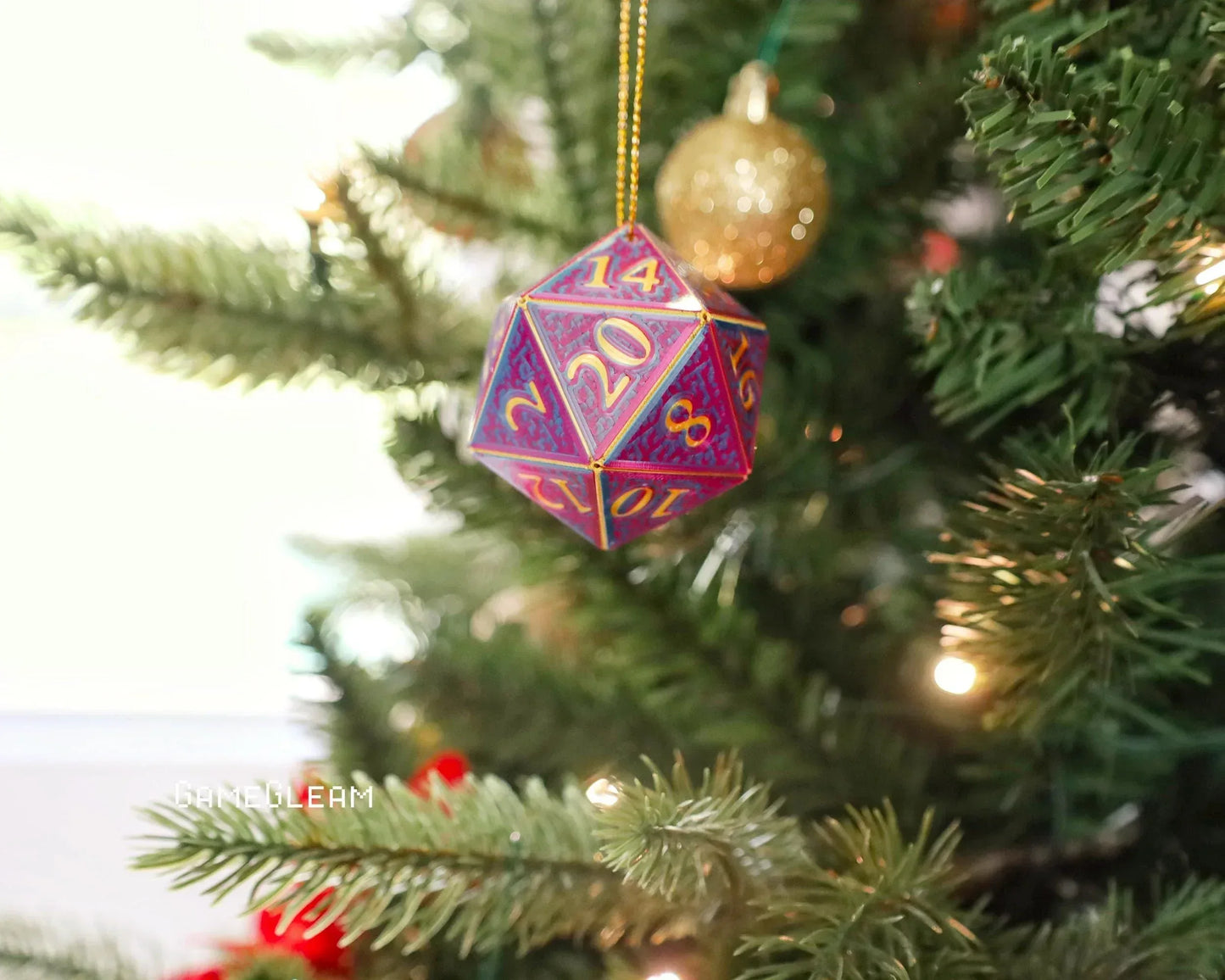 Purple and gold holographic 20-sided dice ornament hanging on a Christmas tree