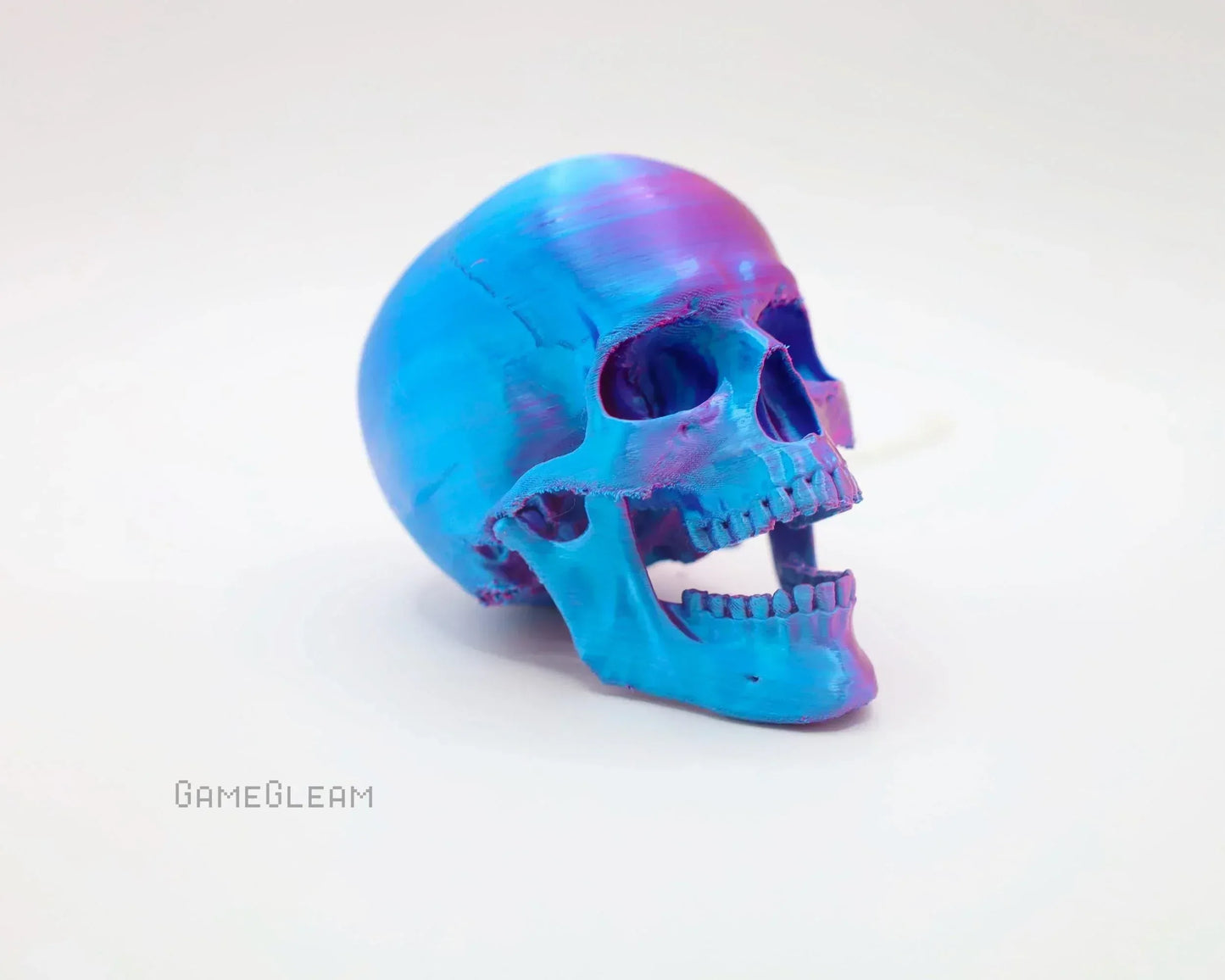 Colorful holographic blue and purple resin skull decor on a white background