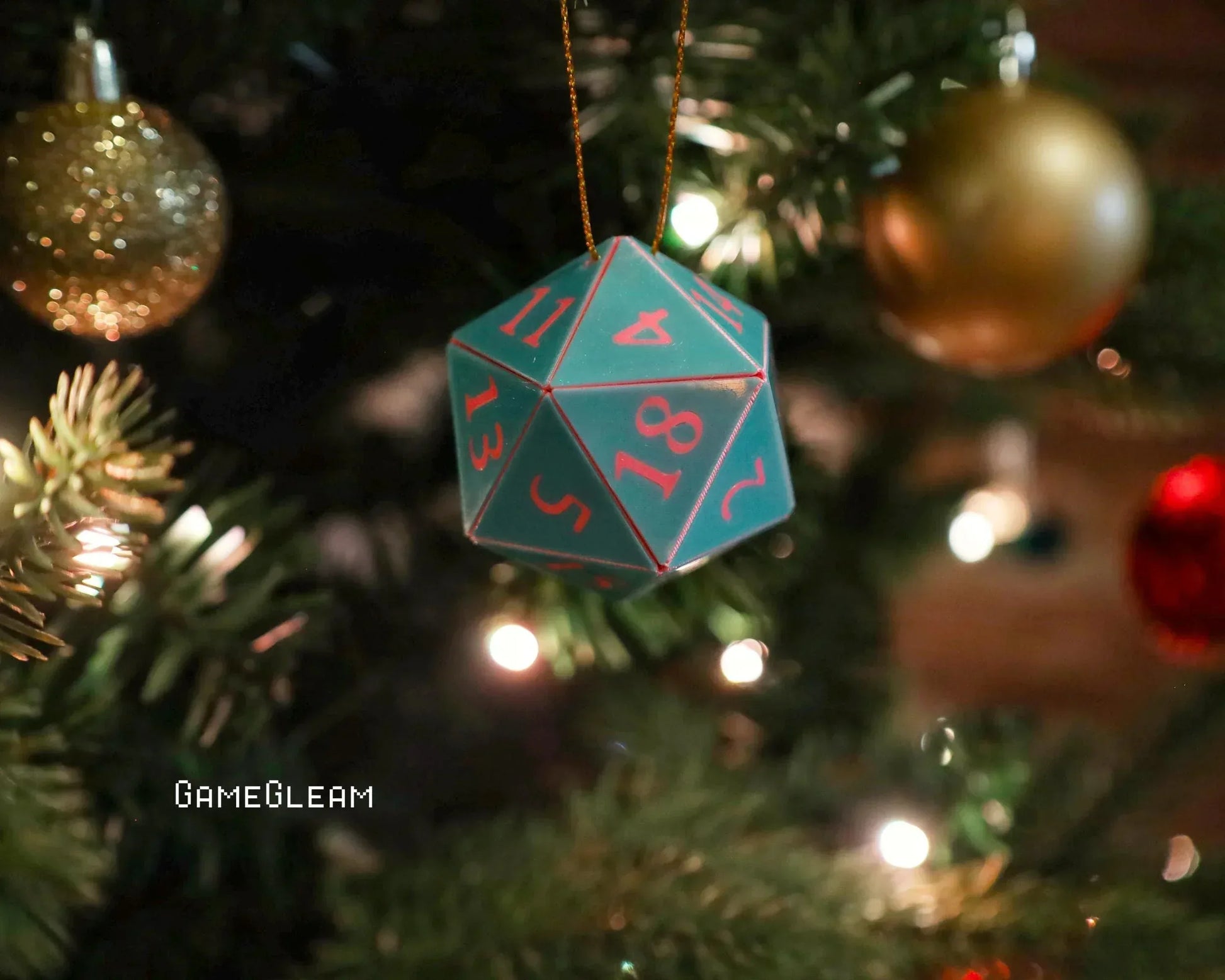 Green twenty-sided dice ornament with red numbers hanging on a decorated Christmas tree