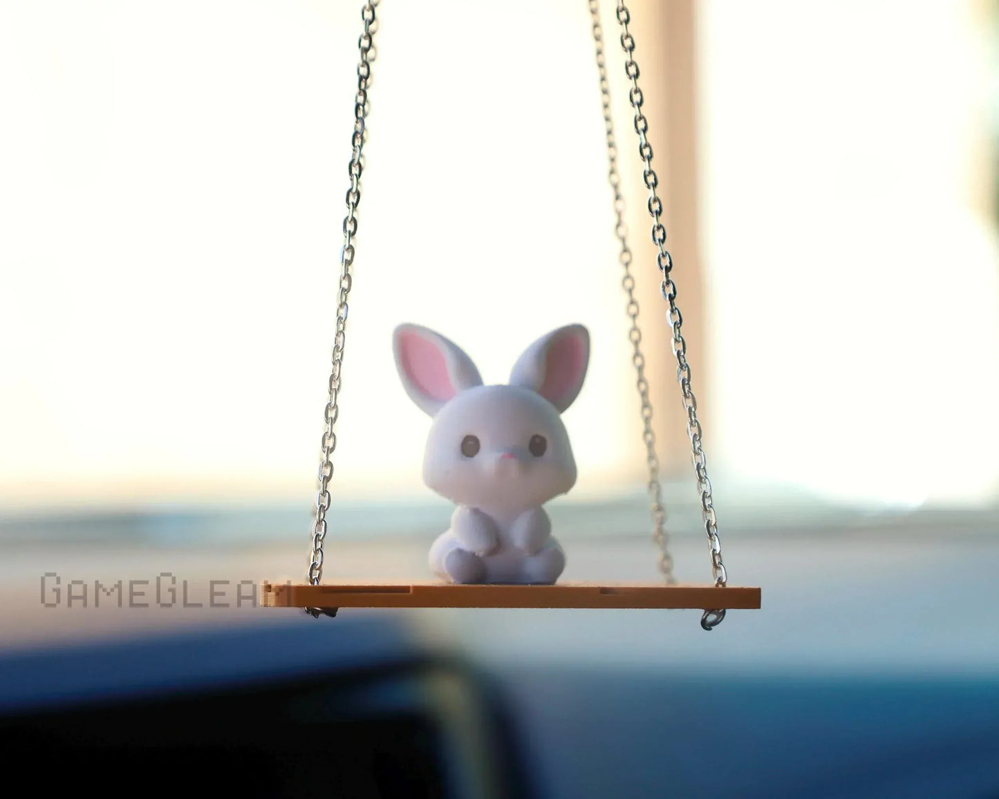 Cute bunny car charm on a swing with chains, hanging from rearview mirror, soft pastel colors