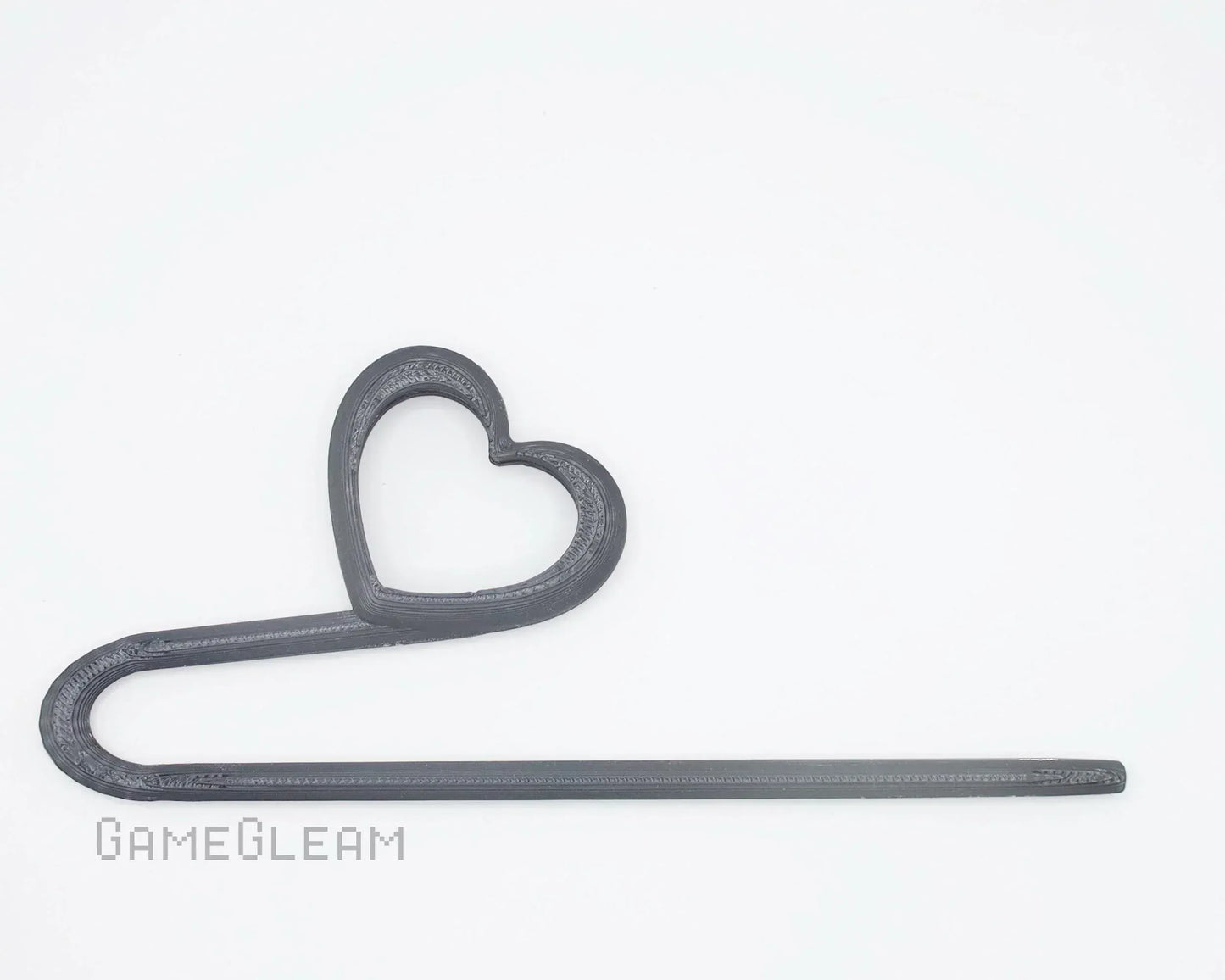 Black 3D printed heart-shaped car dice charm on white background