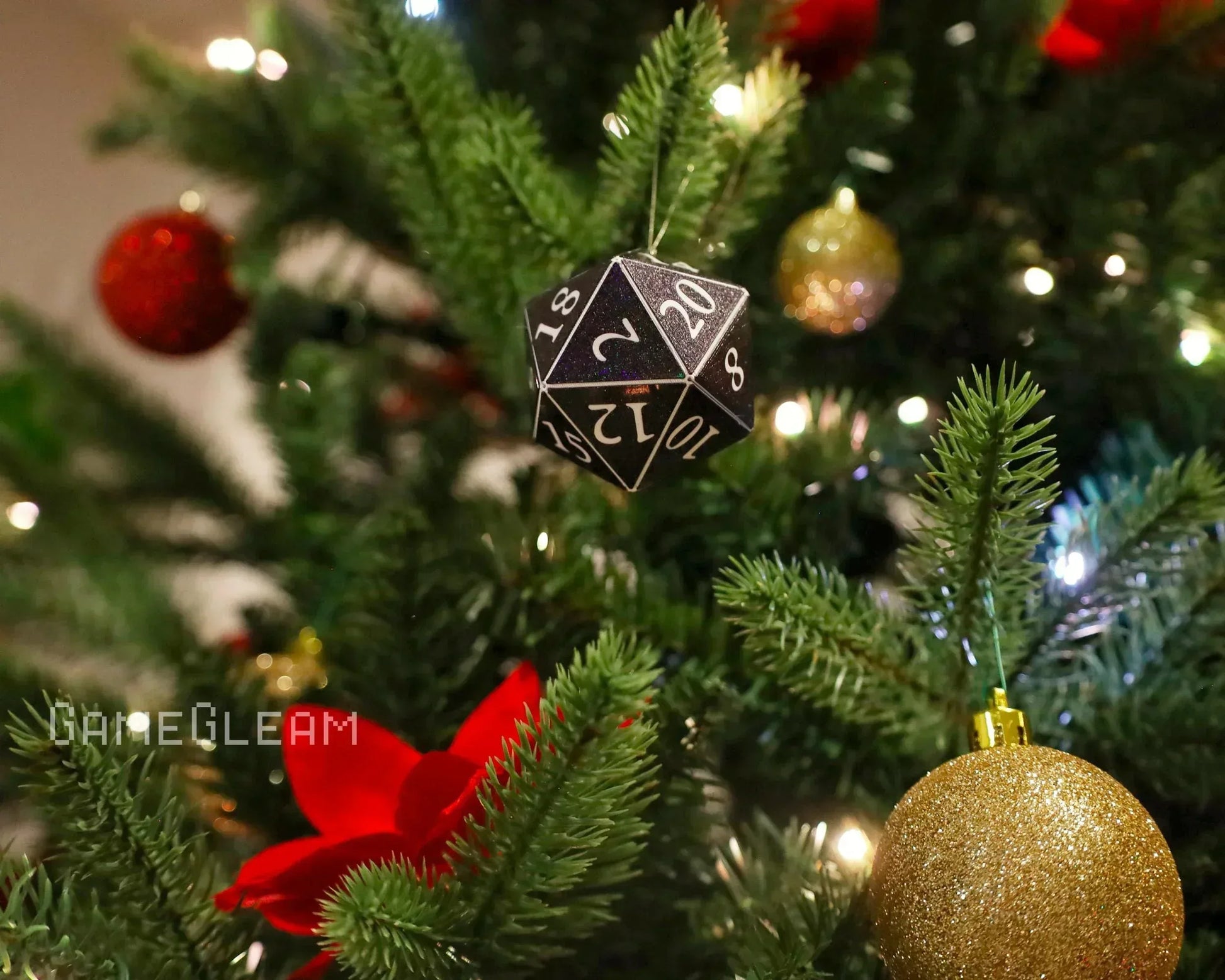 Black twenty-sided dice ornament hanging on a decorated Christmas tree with festive lights