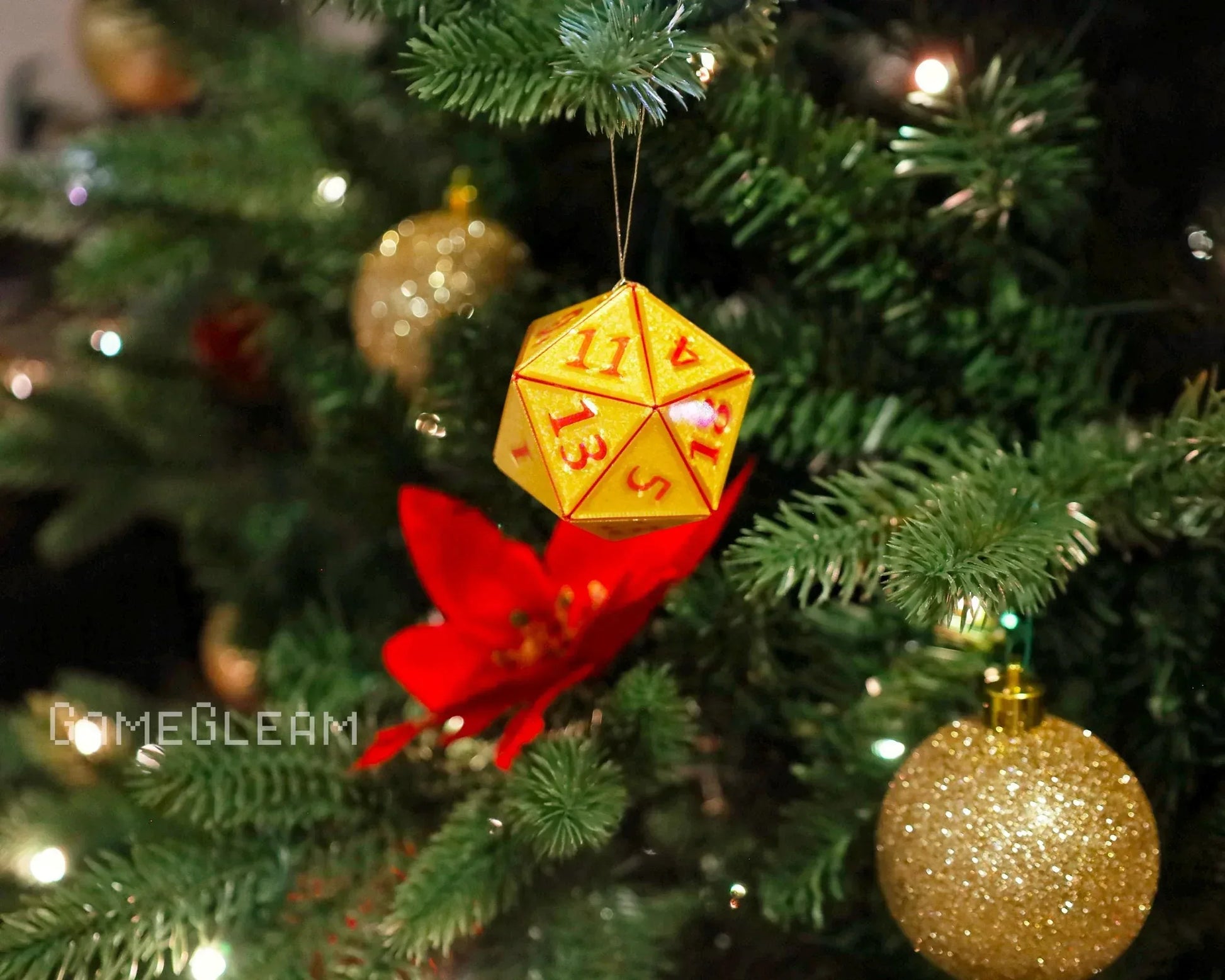 Yellow twenty-sided dice Christmas ornament hanging on a festive tree with red and gold decorations.