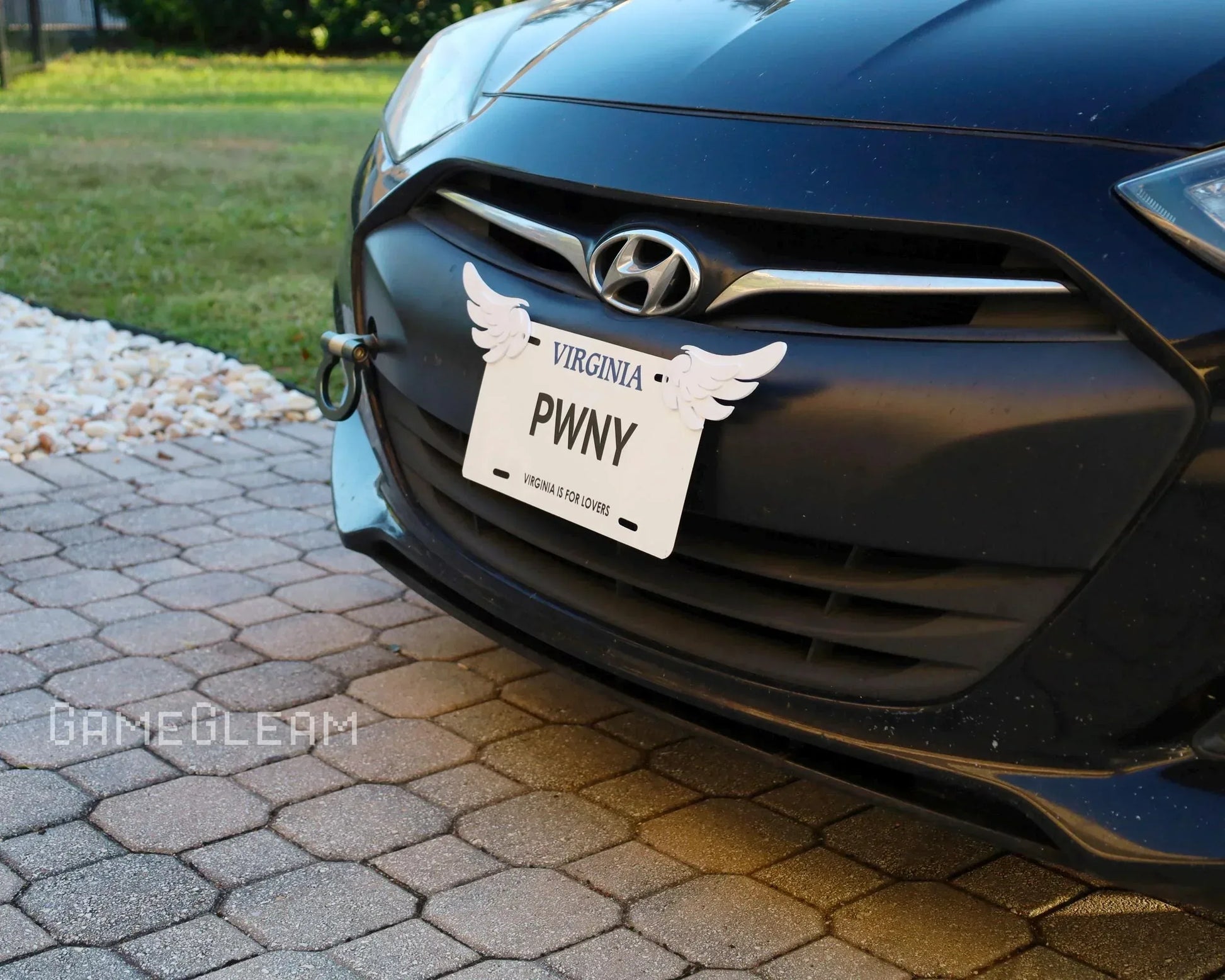 Virginia novelty license plate with wing decals on a black Hyundai front bumper, outdoor driveway