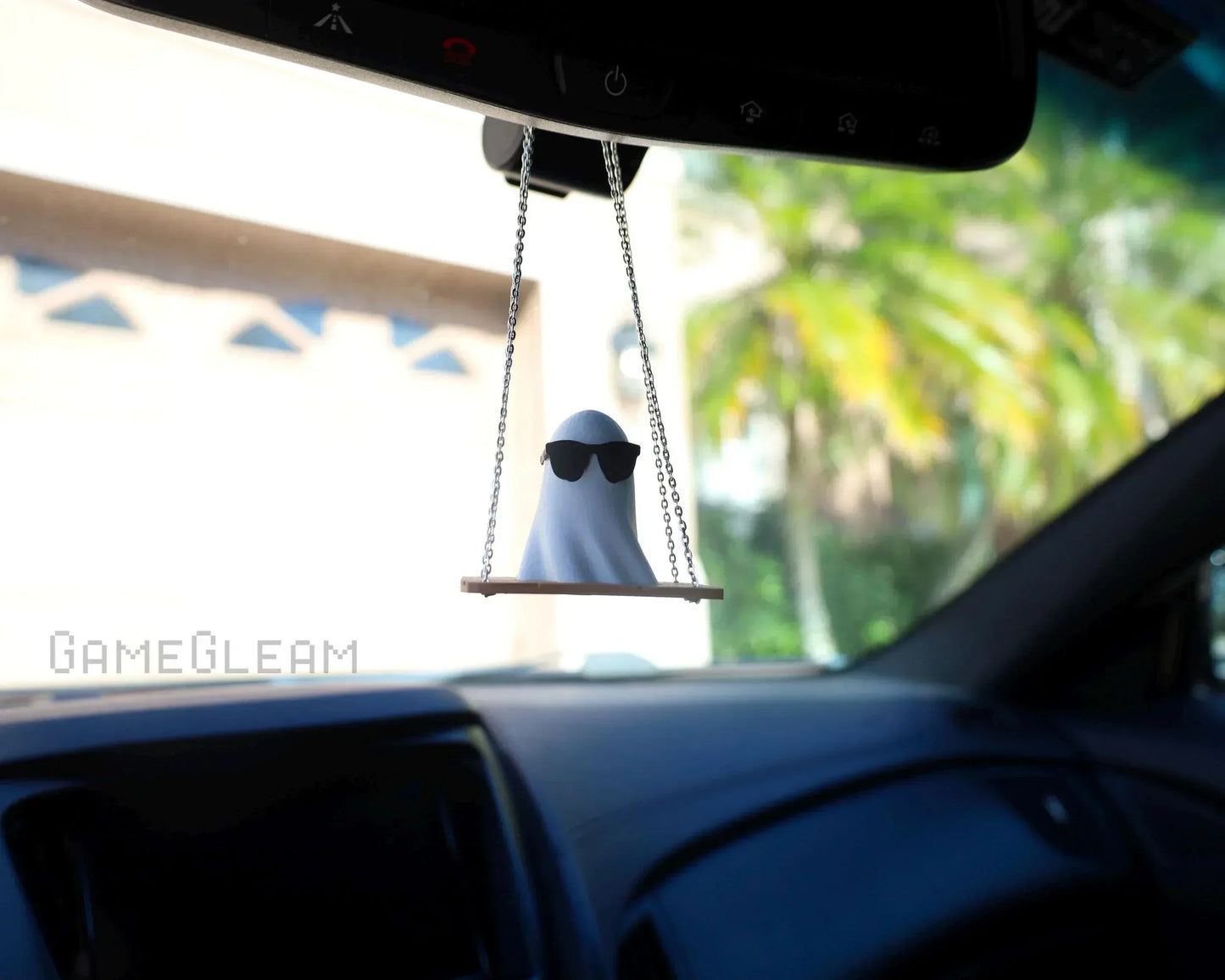 Handmade ghost car charm wearing sunglasses, hanging from rearview mirror on a swing.