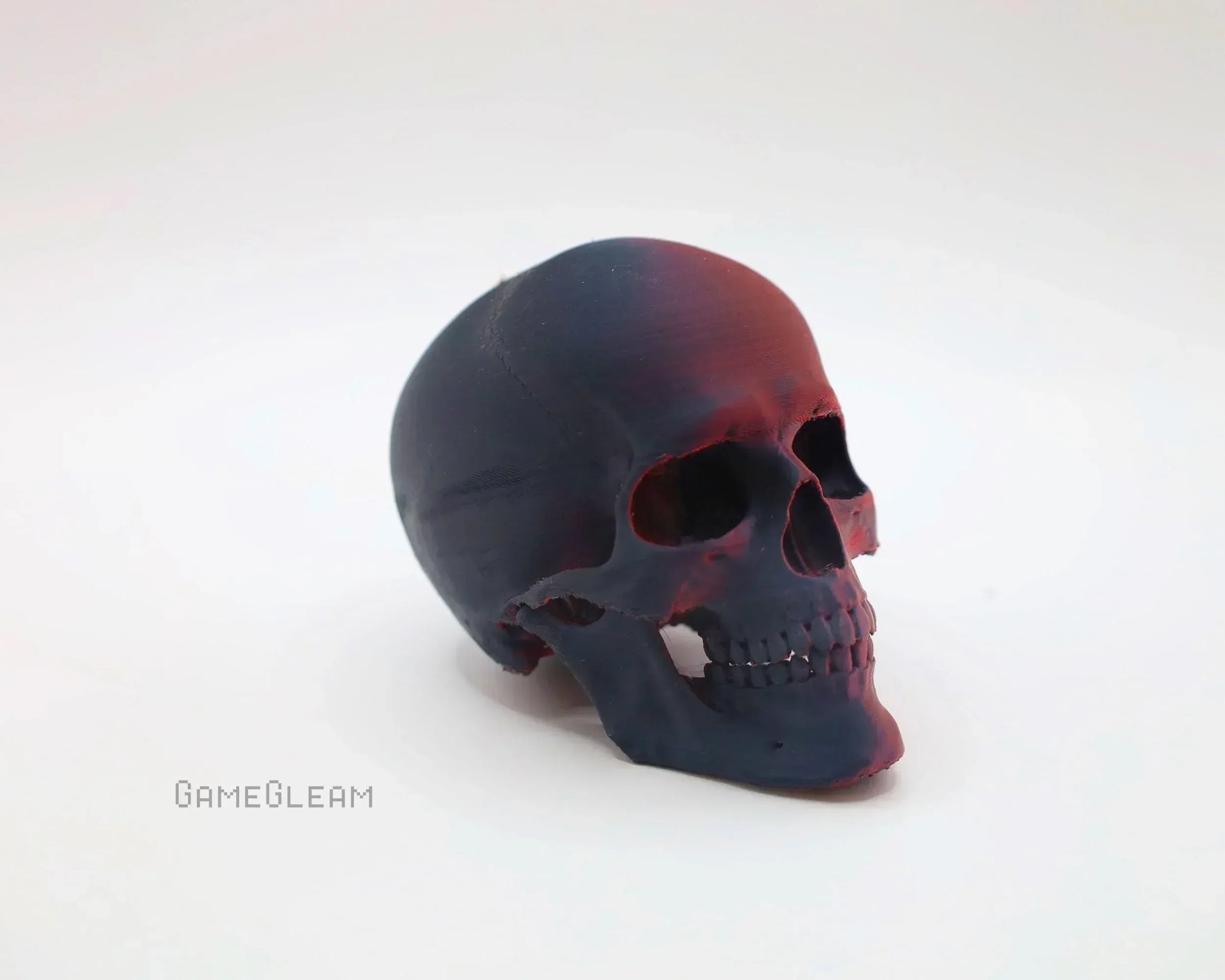 Handmade black resin skull decor with red accents, photographed on a white background.