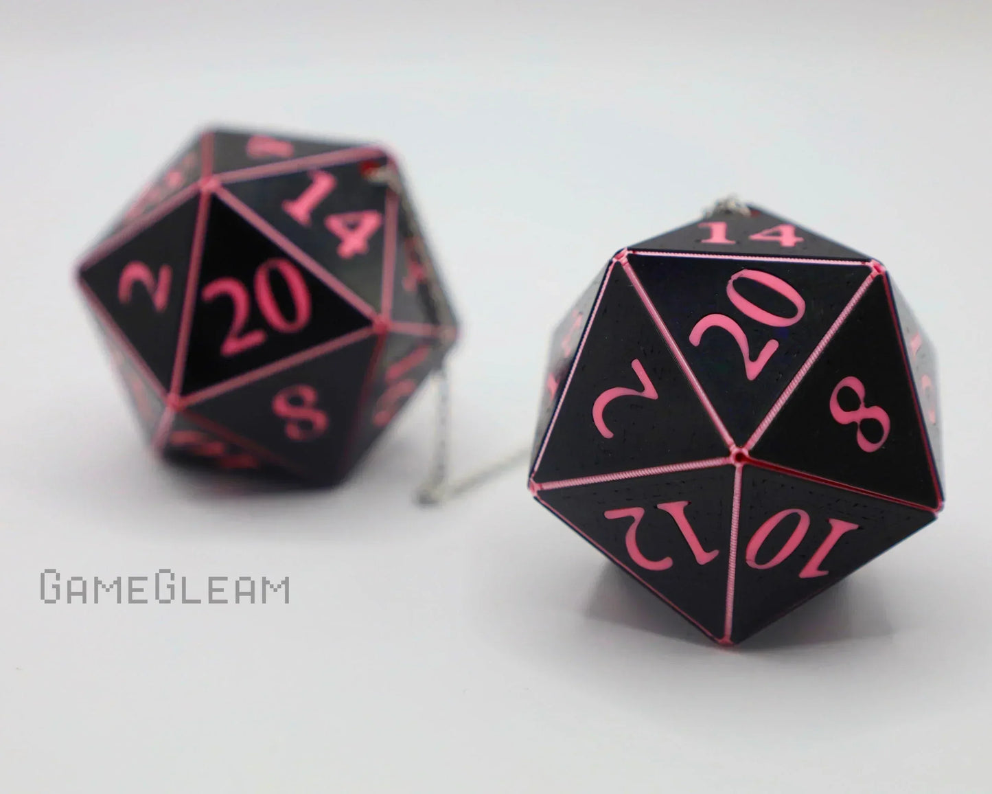 Black and pink twenty-sided dice car charms on a white background, gamer gift accessory