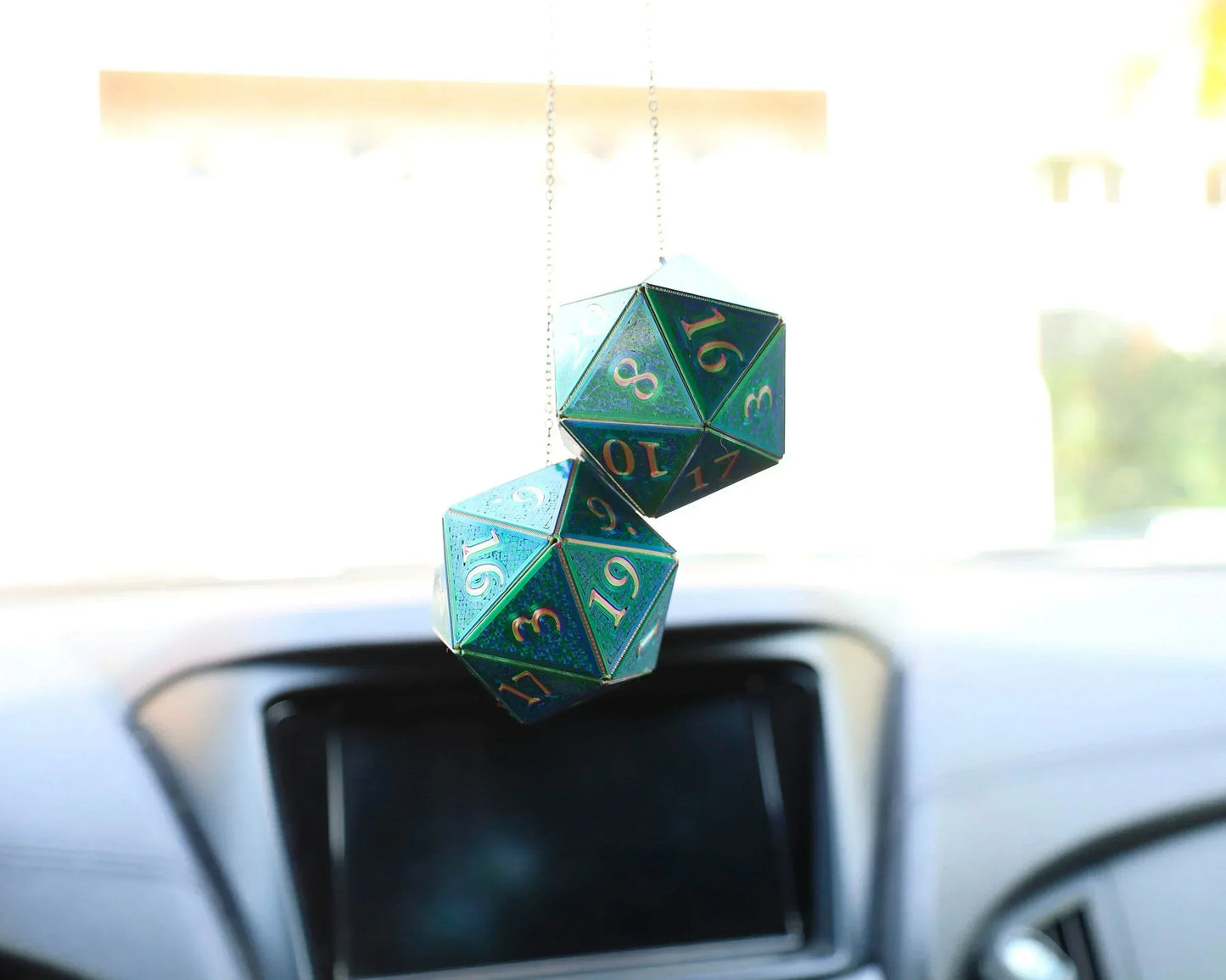 Holographic green twenty-sided dice car hanging charm in a vehicle interior