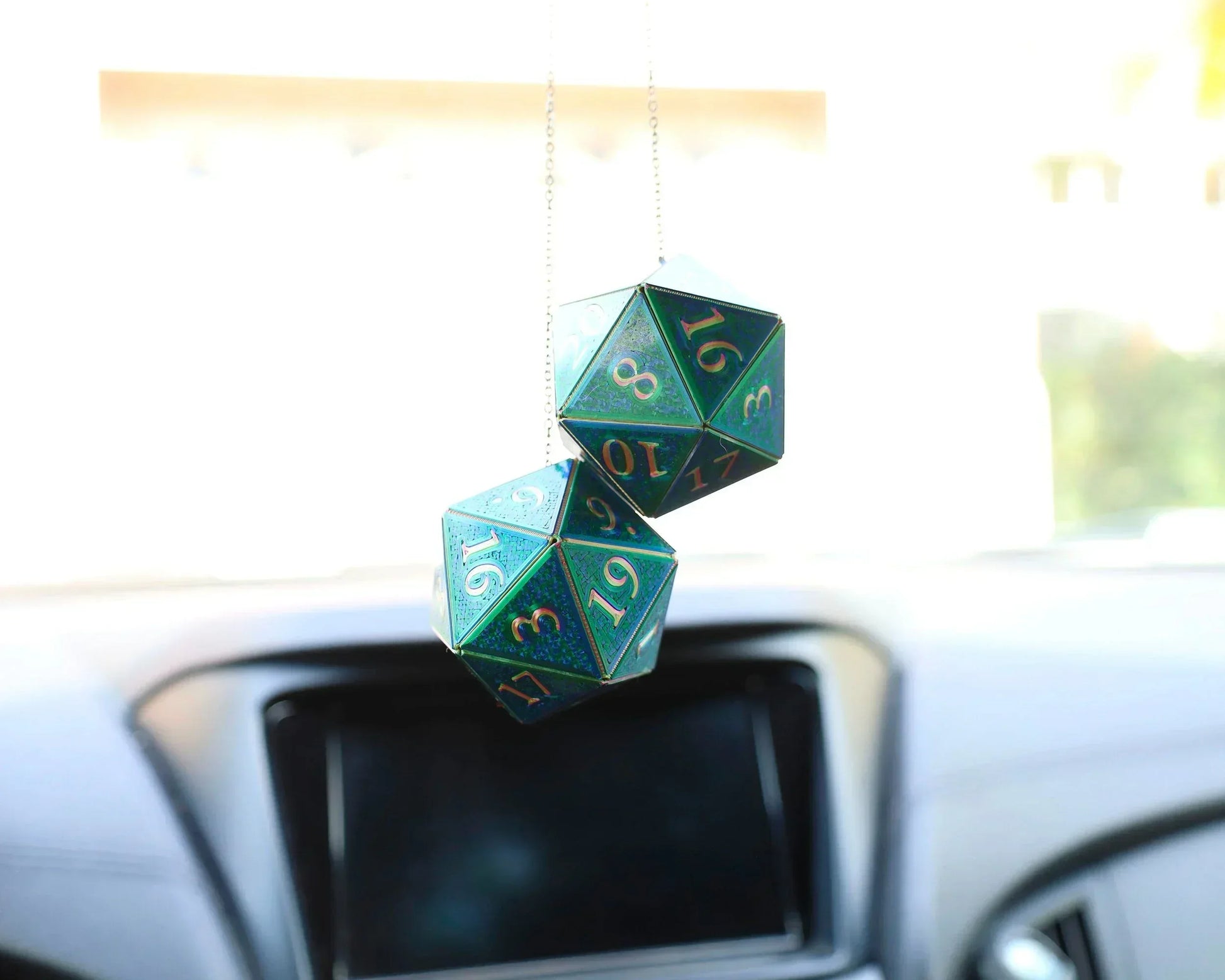 Holographic green twenty-sided dice car hanging charm in a vehicle interior