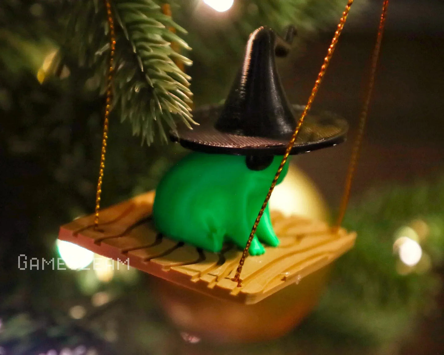Green frog figurine with black wizard hat on swing Christmas tree ornament