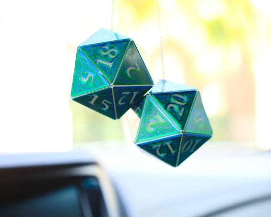 Holographic blue green D20 dice car charm hanging from a rearview mirror
