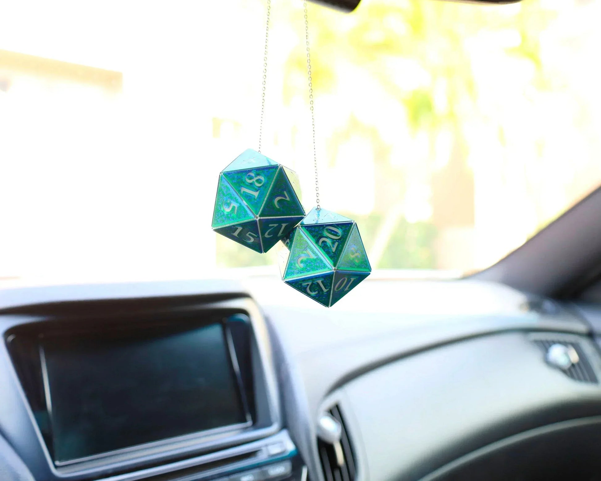 Holographic teal D20 dice car hanging charm in a modern car interior, perfect gamer gift