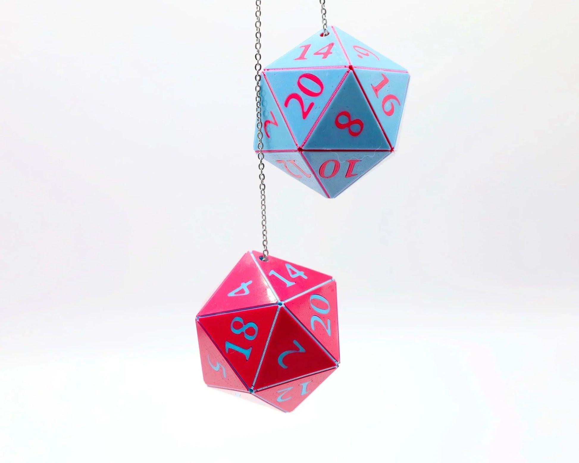 Hanging blue and pink twenty-sided dice charms with bold numbers on a white background