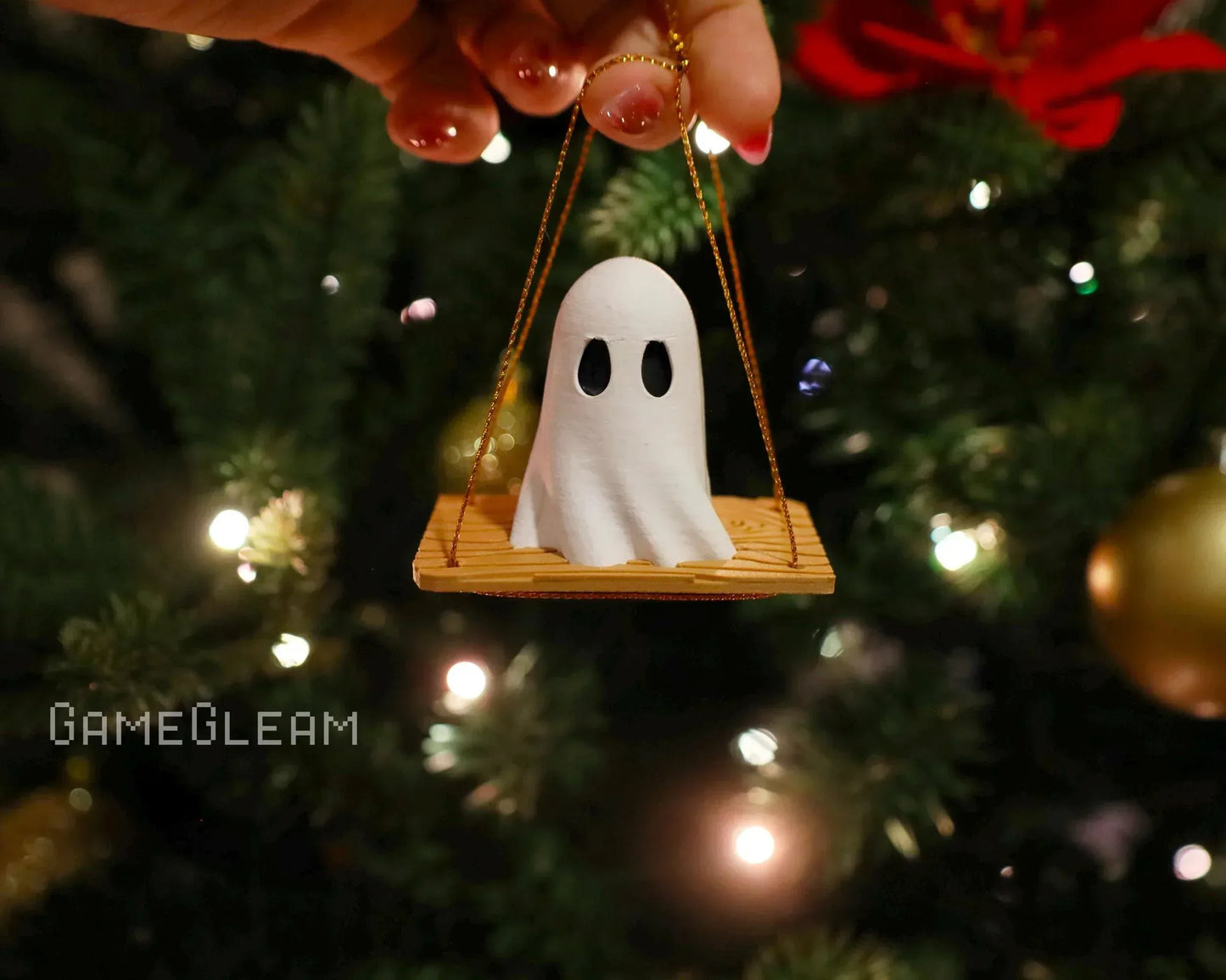 Handmade ghost ornament on a wooden swing hanging from a Christmas tree