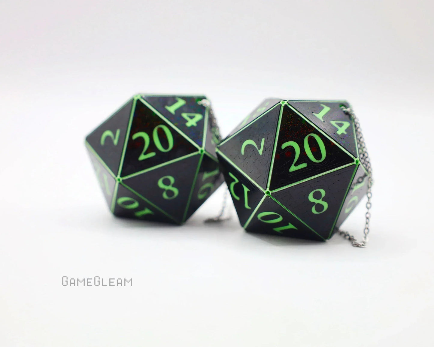 Pair of holographic black 20-sided dice with green numbers on silver chains for gamer car decor.