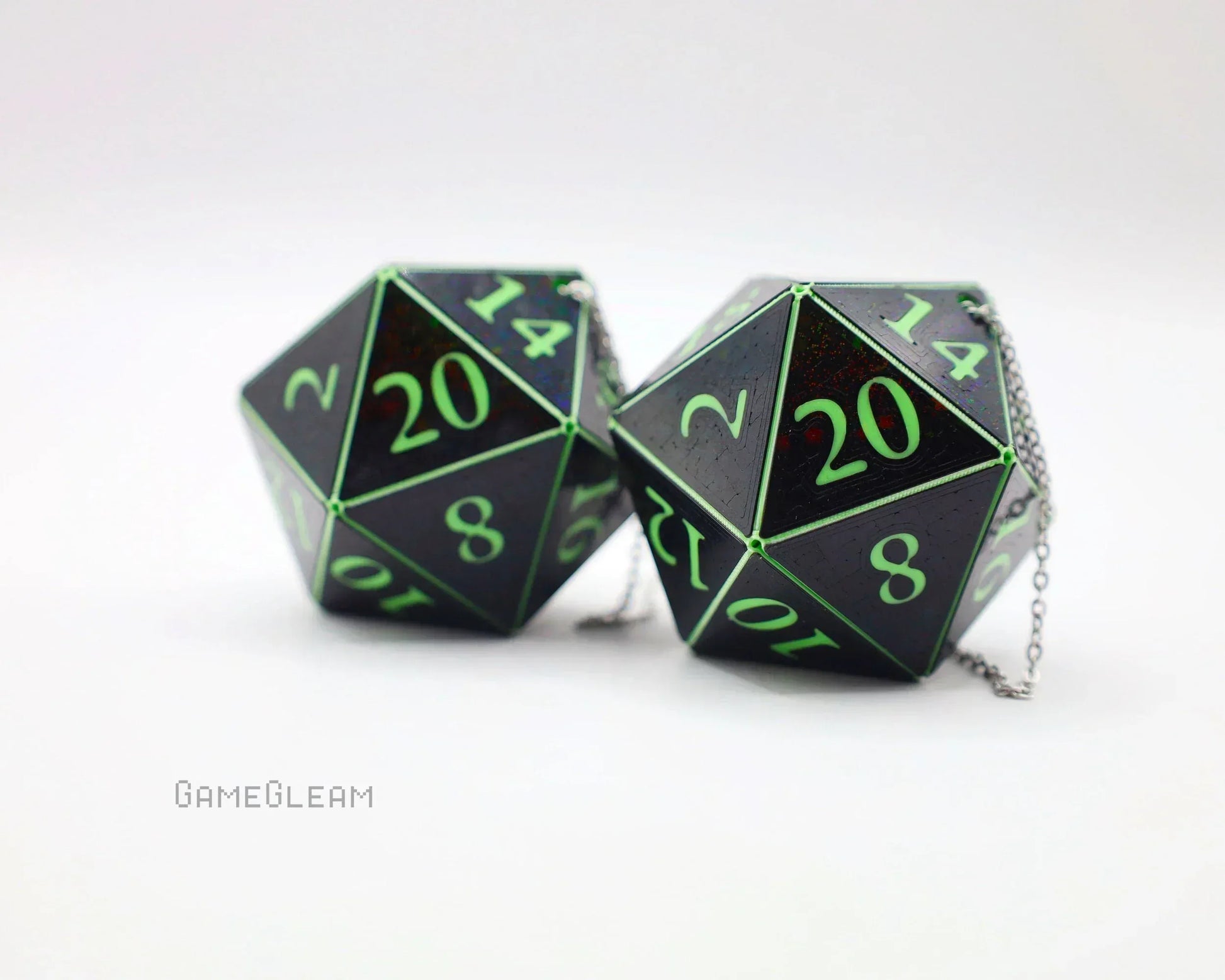 Pair of holographic black 20-sided dice with green numbers on silver chains for gamer car decor.