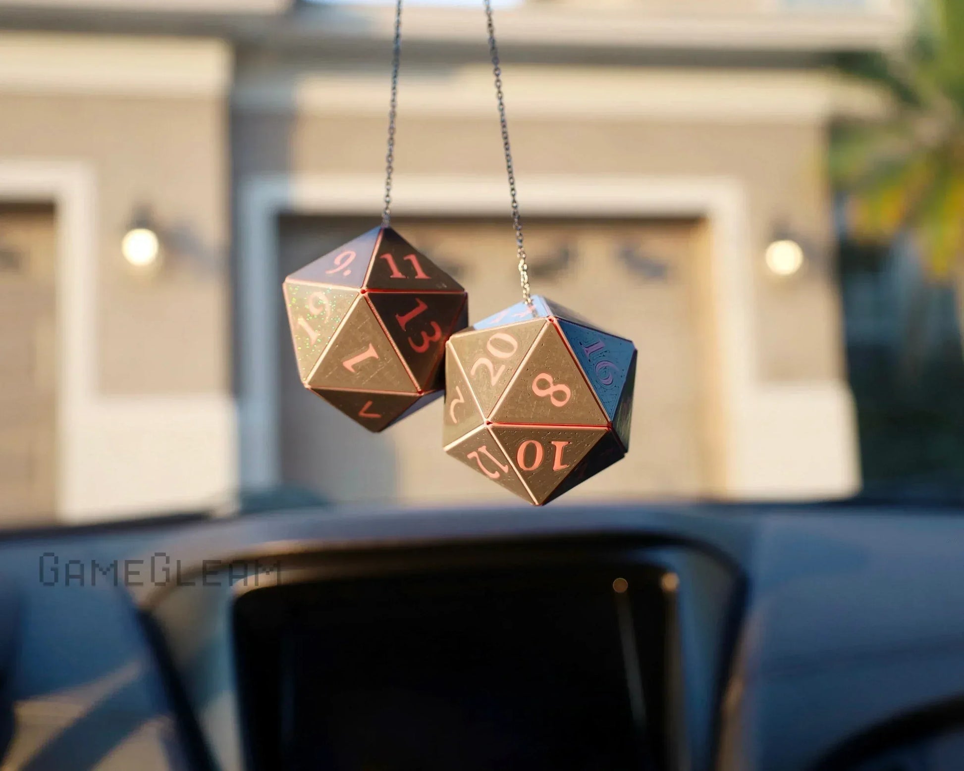 Holographic 20-sided dice car charm hanging from rearview mirror, sunlight reflecting.