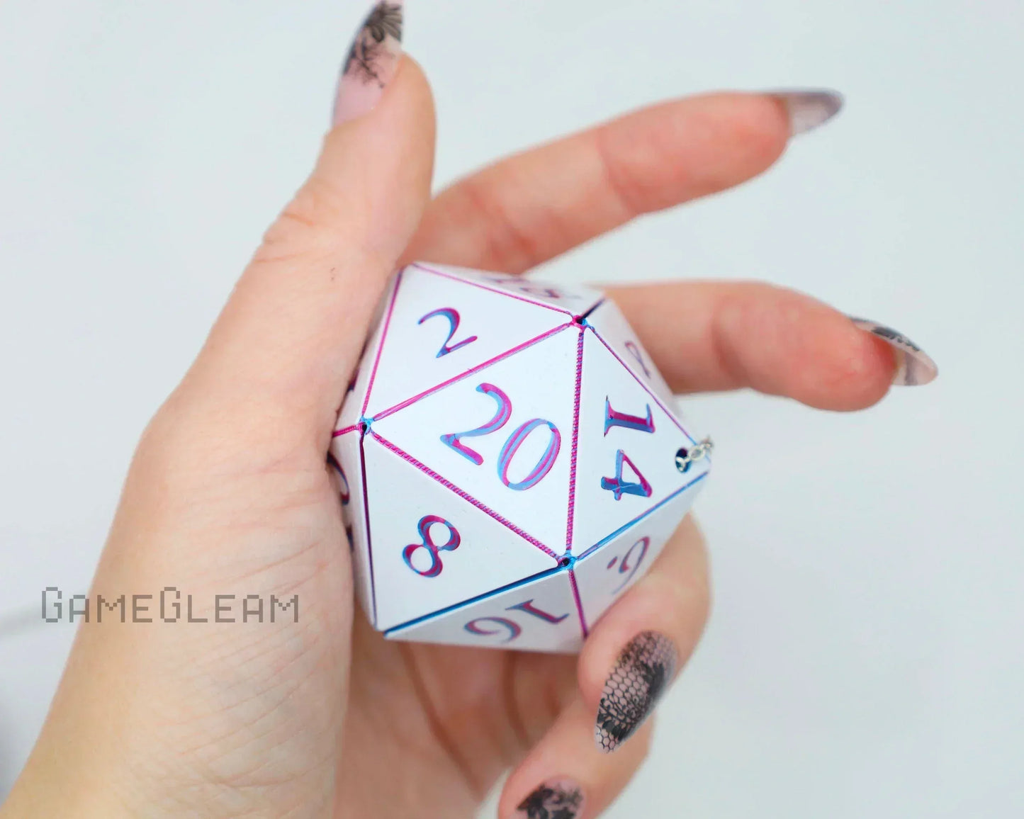 Hand holding a white holographic twenty-sided dice car charm, tabletop gaming accessory