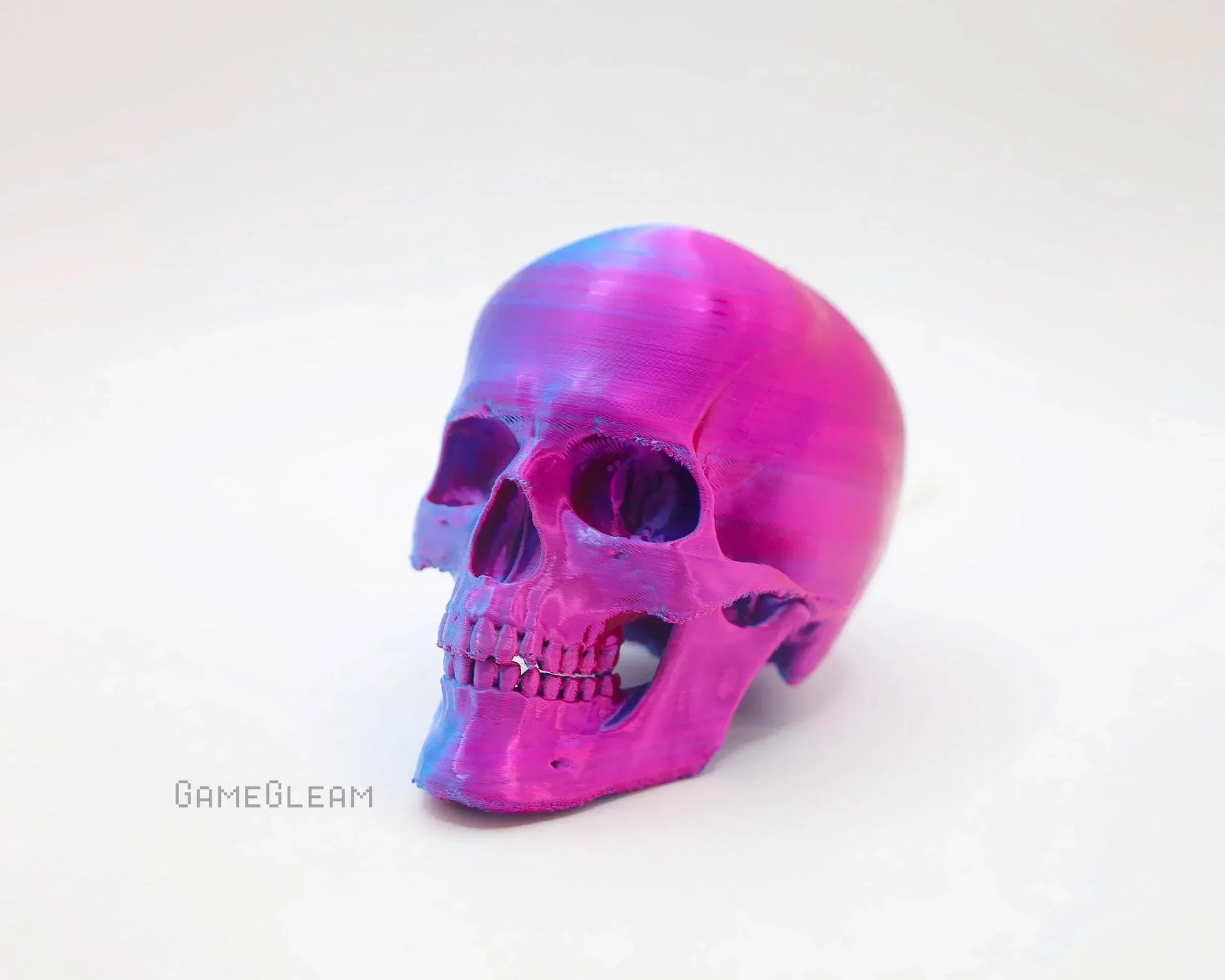Handmade iridescent pink and blue skull decor on white background